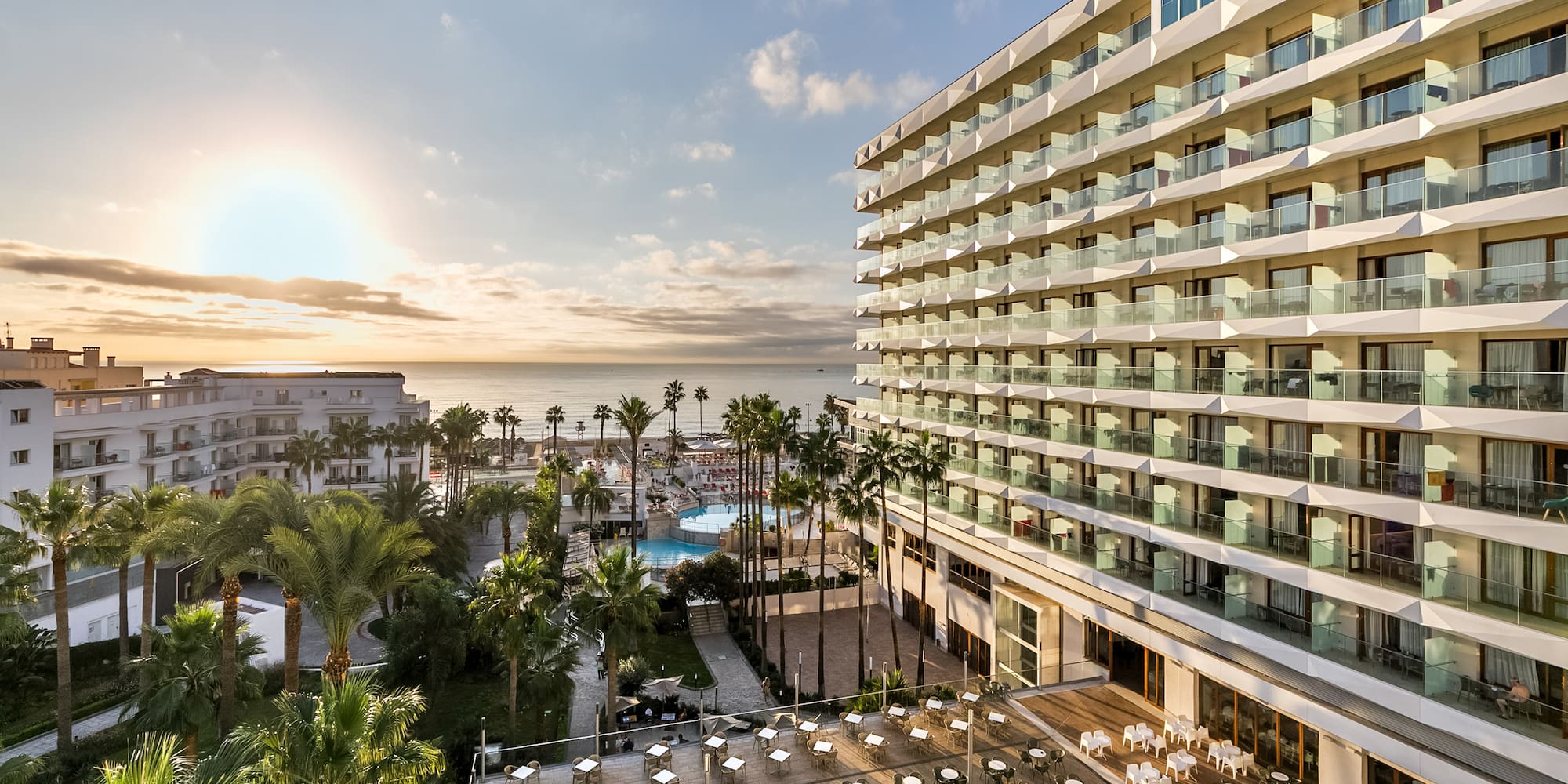 a hotel with a pool and palm trees