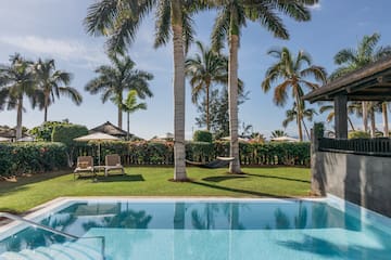 a pool with palm trees and a lawn