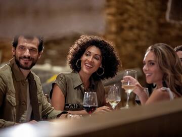 a group of people sitting at a table with wine glasses