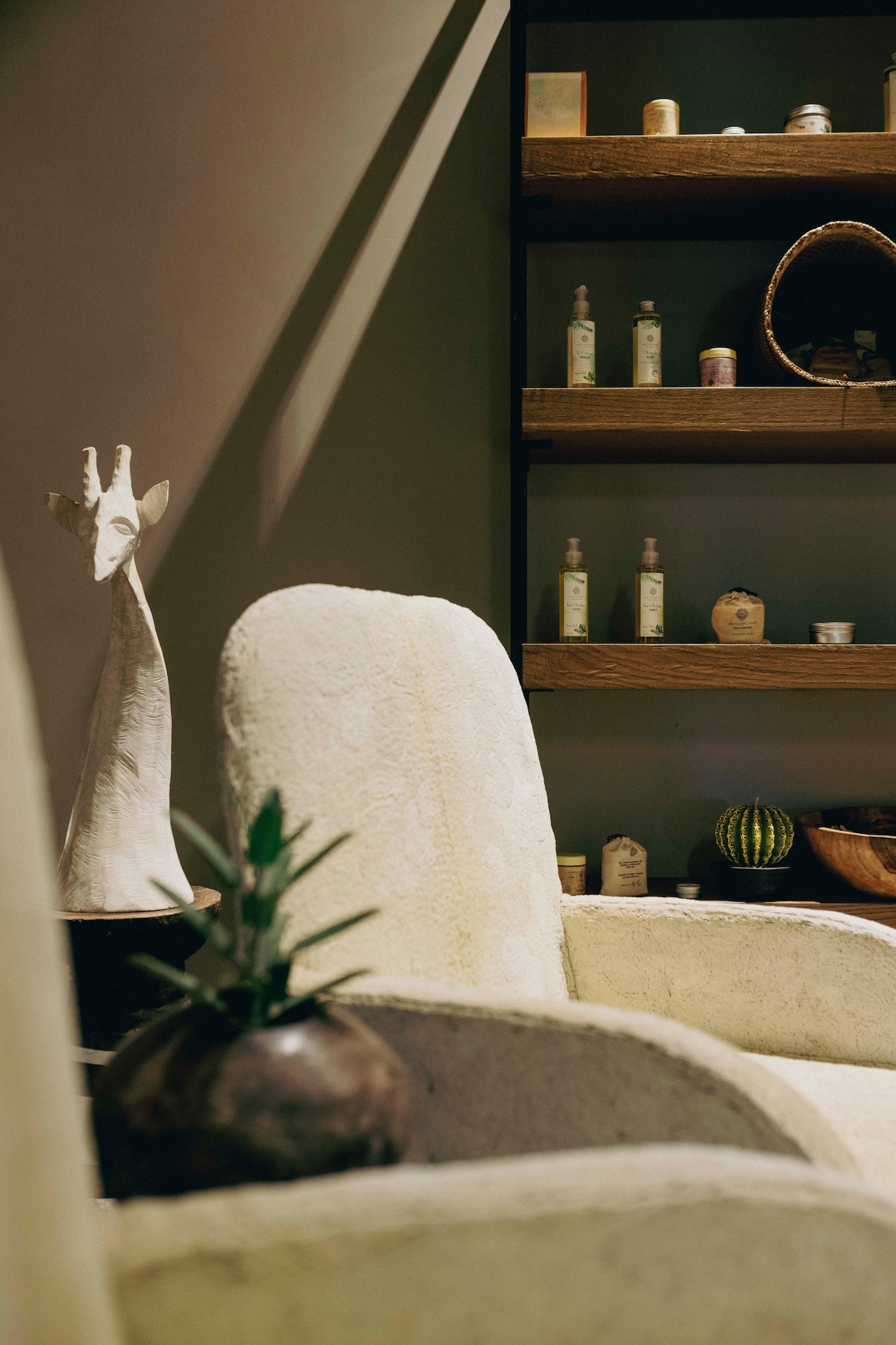 a white chair with a vase on a table with a plant on it