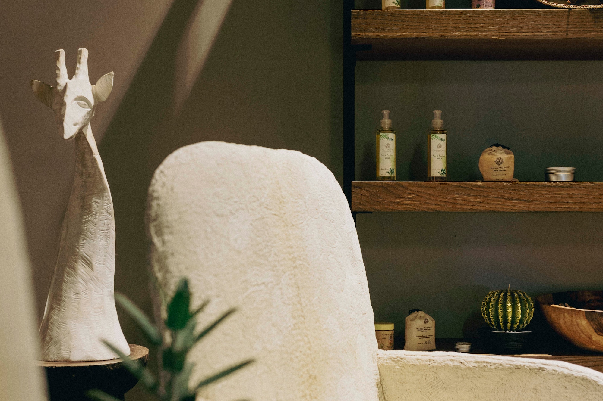 a white chair with a vase on a table with a plant on it