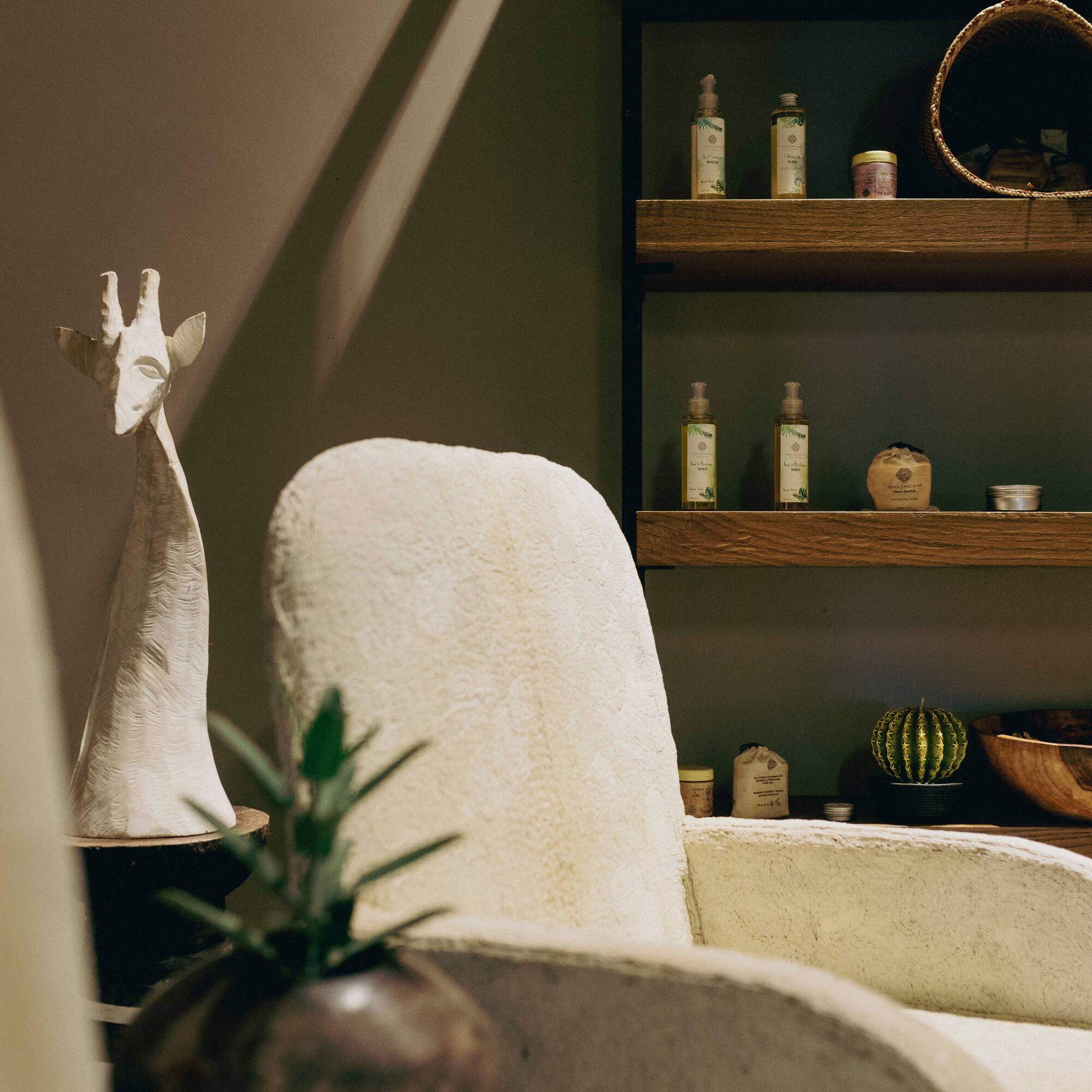 a white chair with a vase on a table with a plant on it