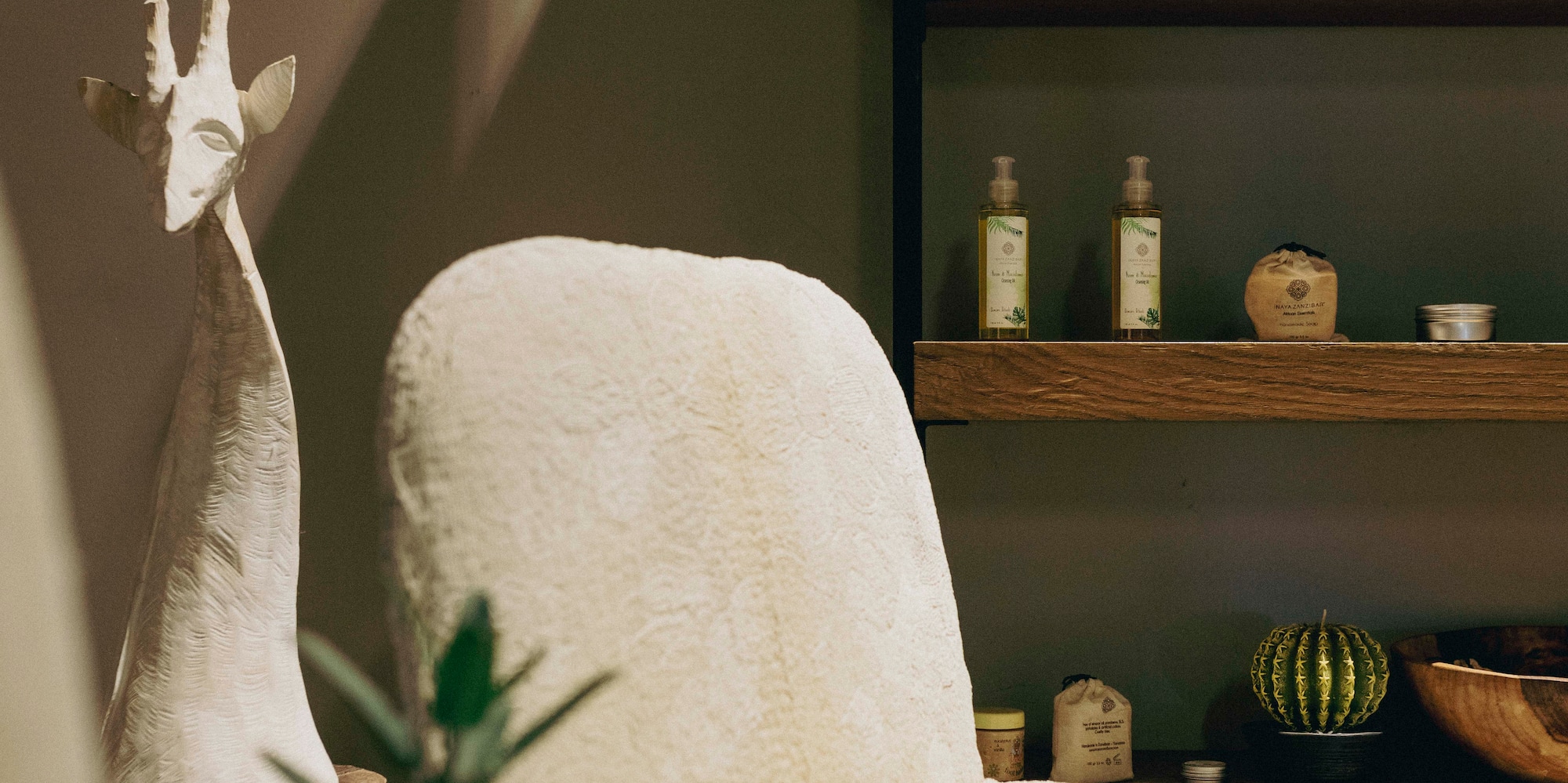 a white chair with a vase on a table with a plant on it