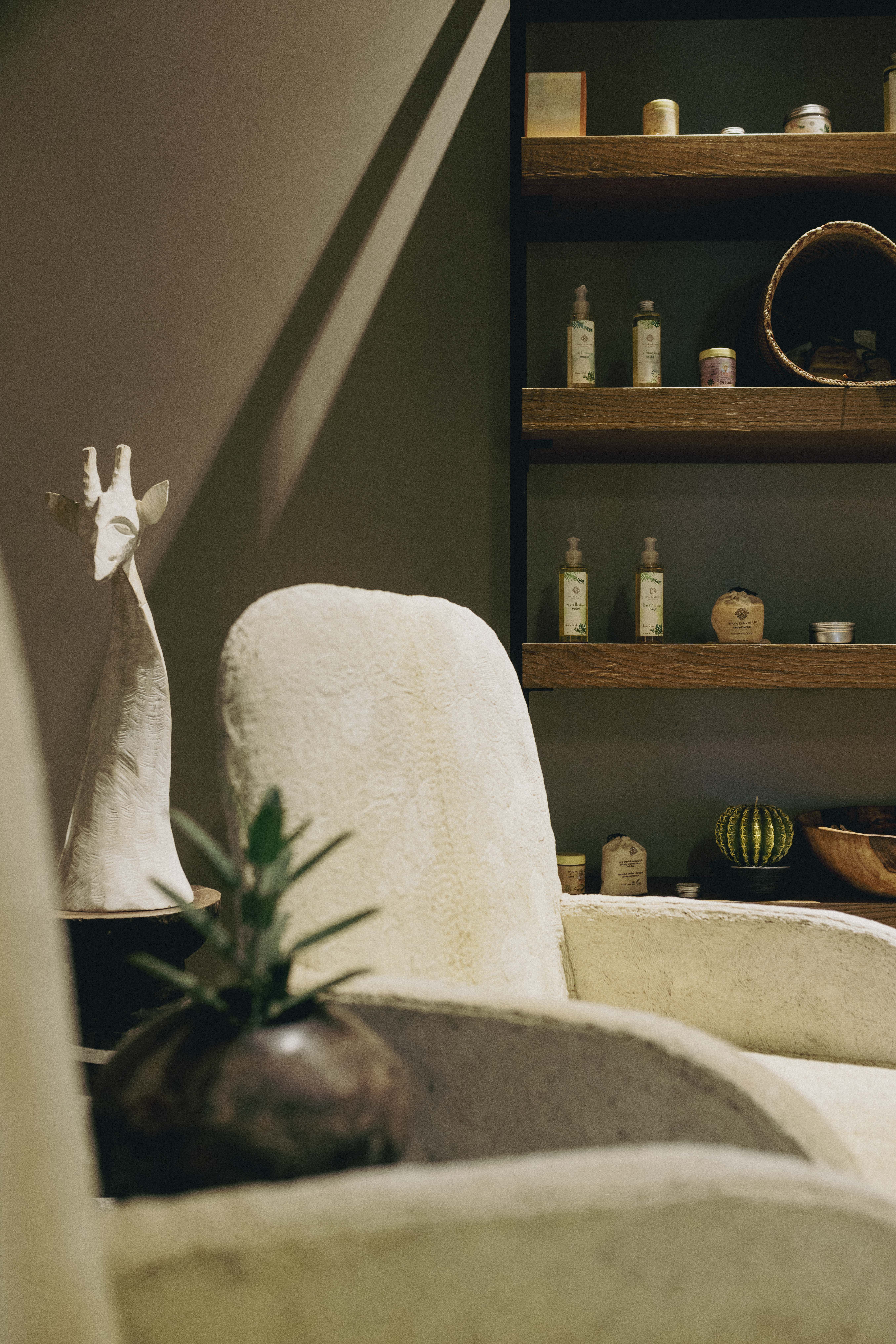Natural spa decor with textured chair, giraffe sculpture, organic products.