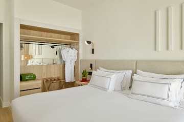 a bed with white sheets and white towels