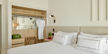 a bed with white sheets and white towels