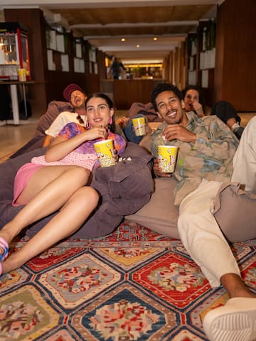 a group of people sitting on a floor with drinks