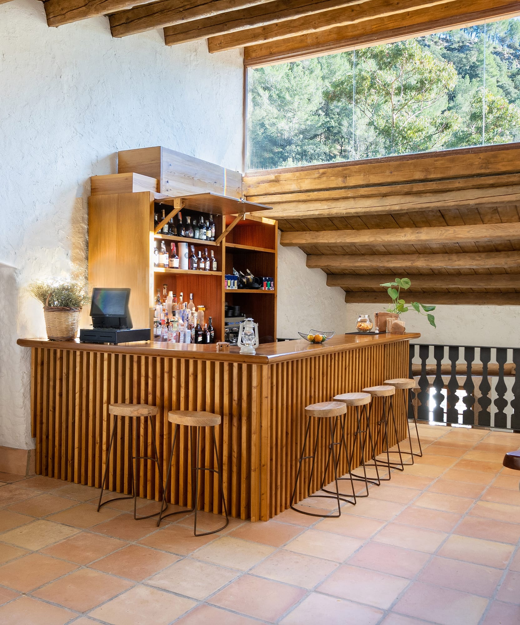 a bar in a room with a roof and chairs