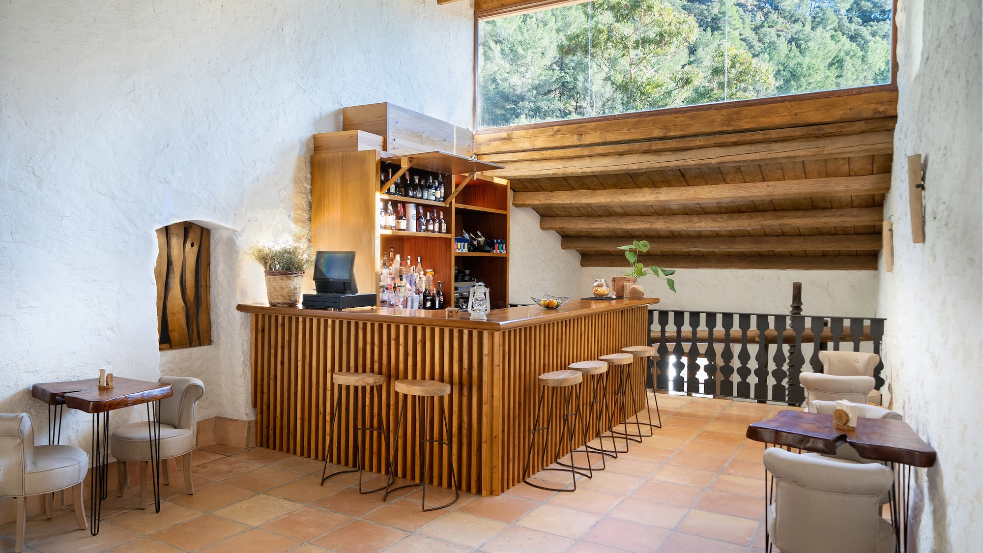 a bar in a room with a roof and chairs