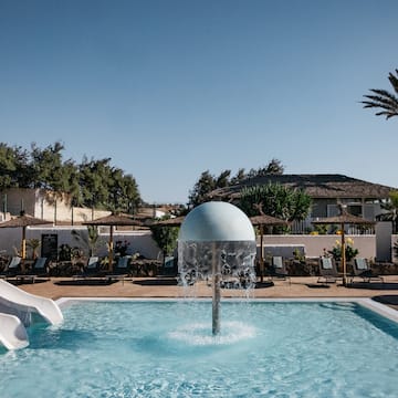 a pool with a water slide and a white ball