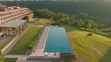 a pool with chairs and a building in the background