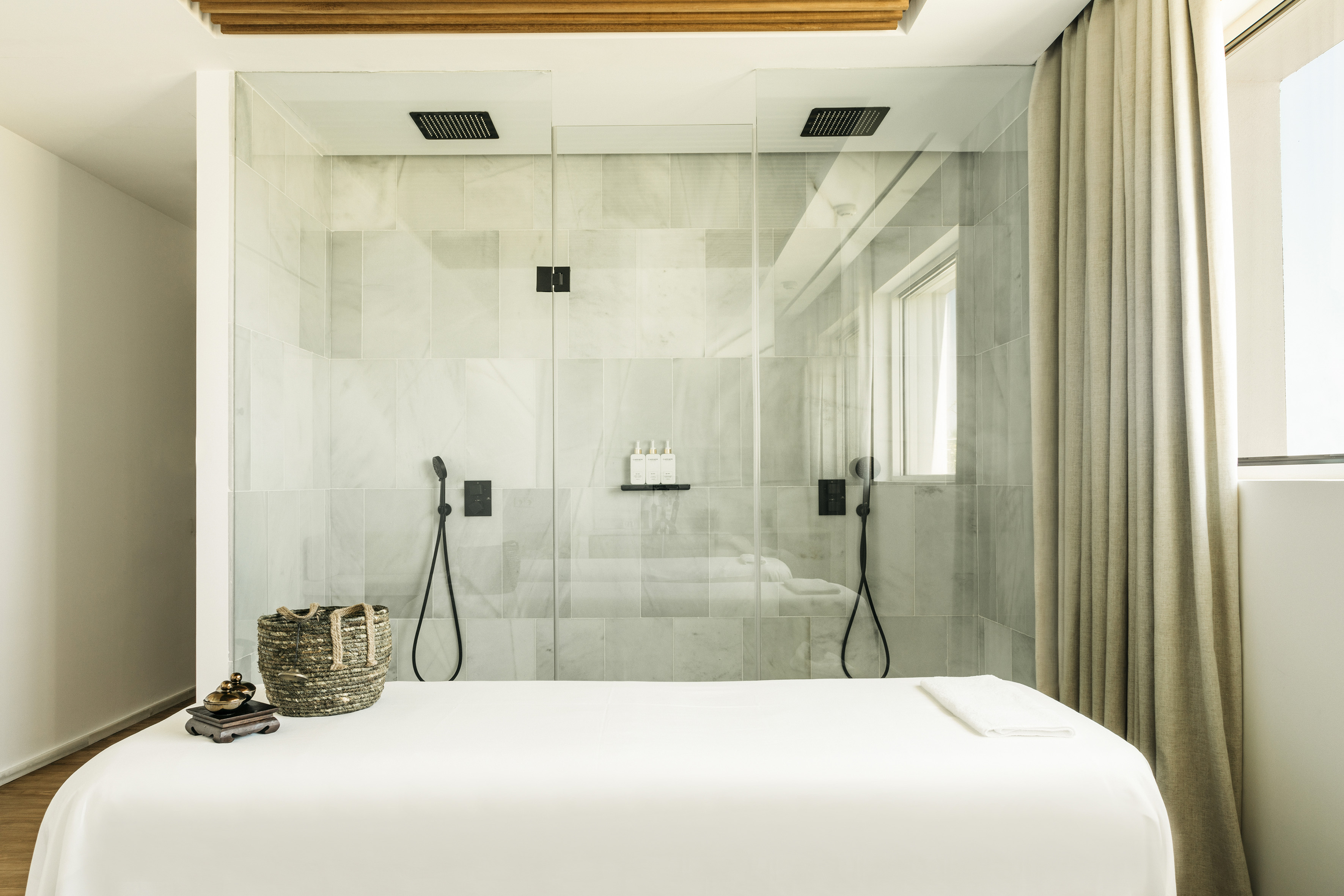 Elegant spa treatment room with massage table and modern marble shower.