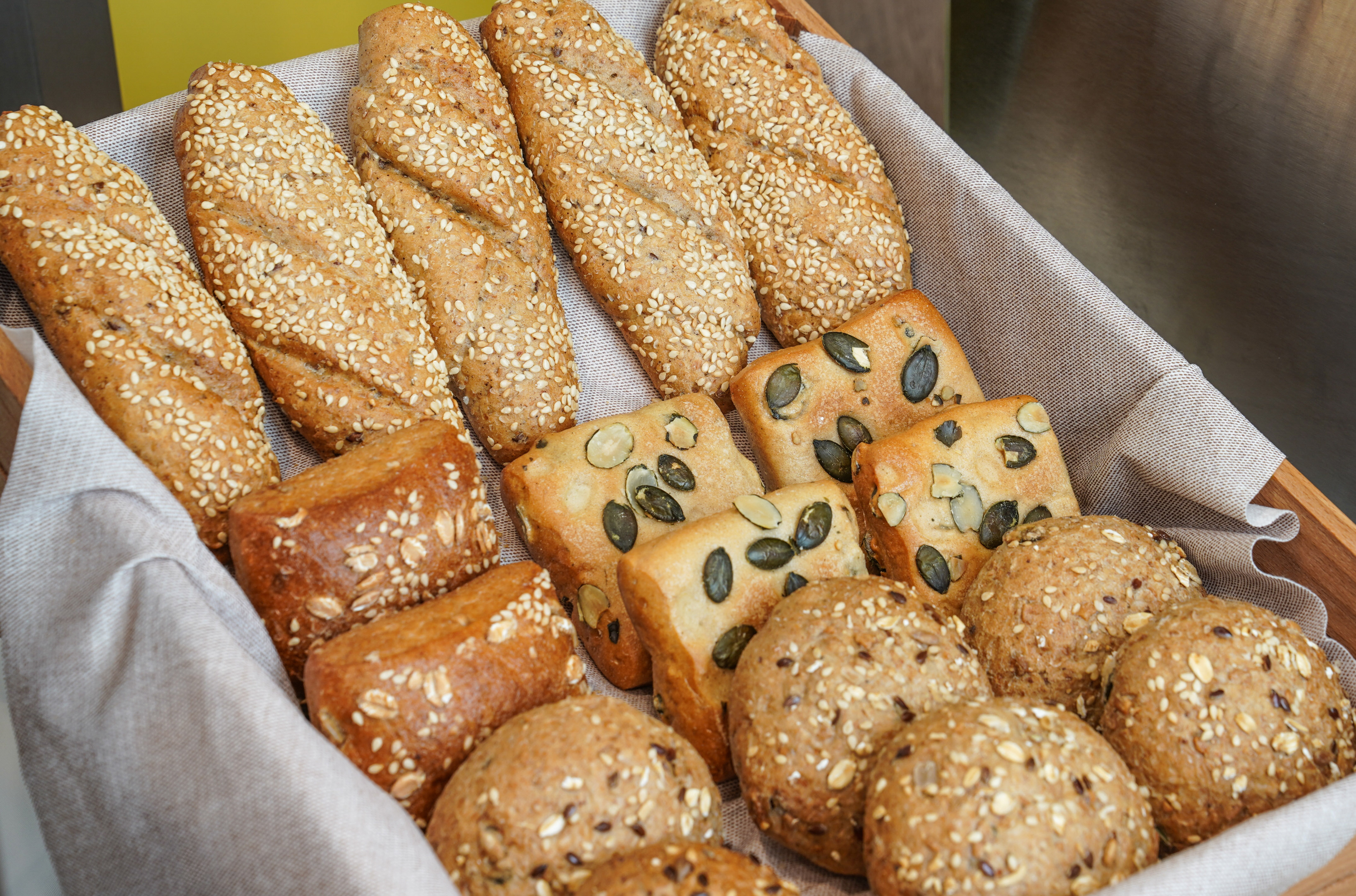 Multigrain bread basket: sesame baguettes, pumpkin seed squares, seeded rolls.