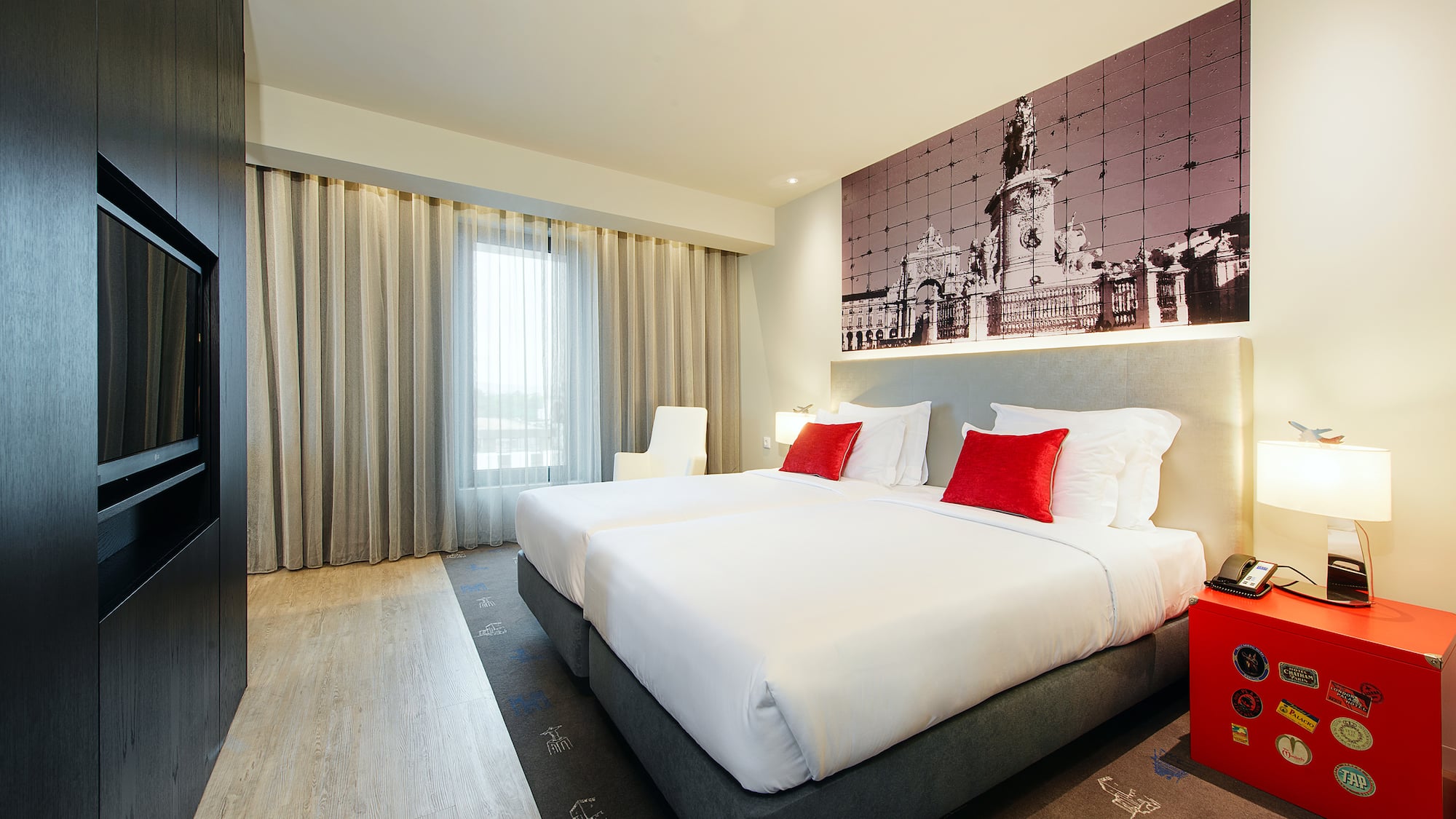 Contemporary hotel twin room featuring Lisbon cityscape wall art.