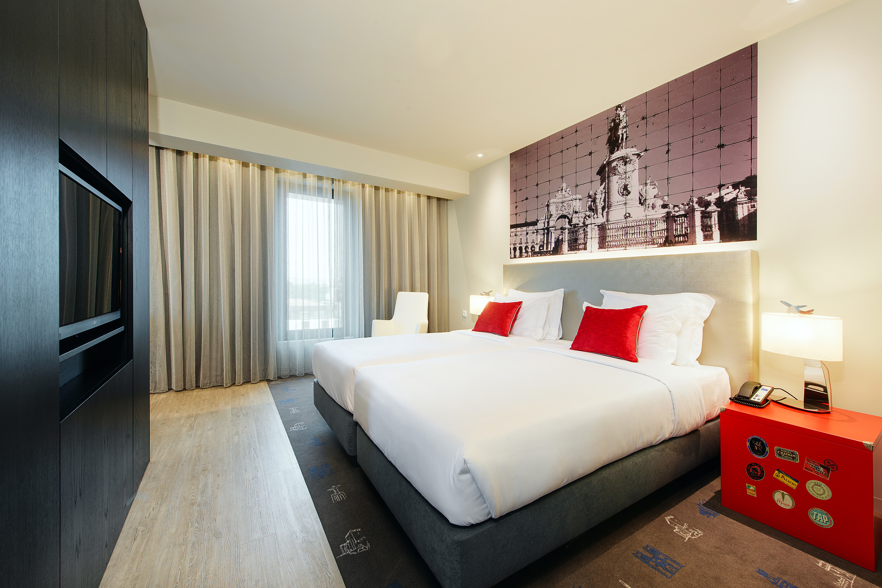 Contemporary hotel twin room featuring Lisbon cityscape wall art.