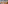 Assorted liquor bottles on illuminated bar shelves, city mural background.