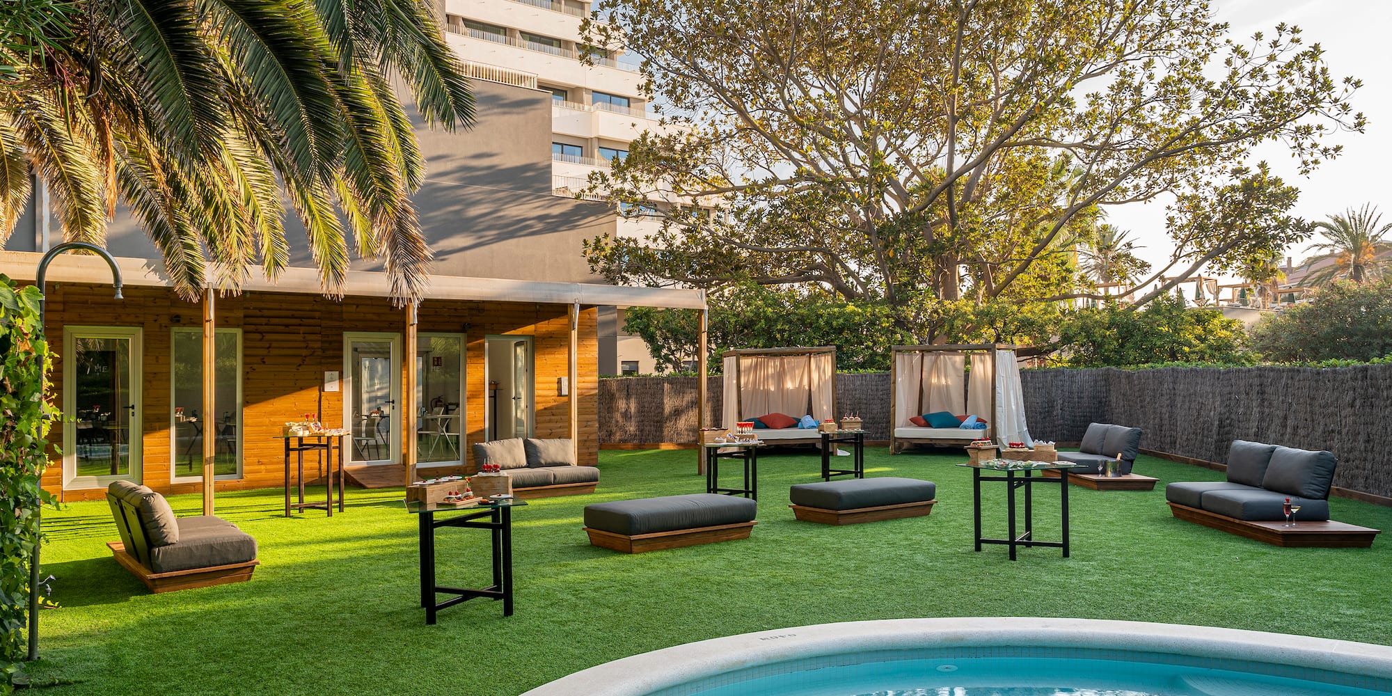 a pool in a backyard with a building and lounge chairs