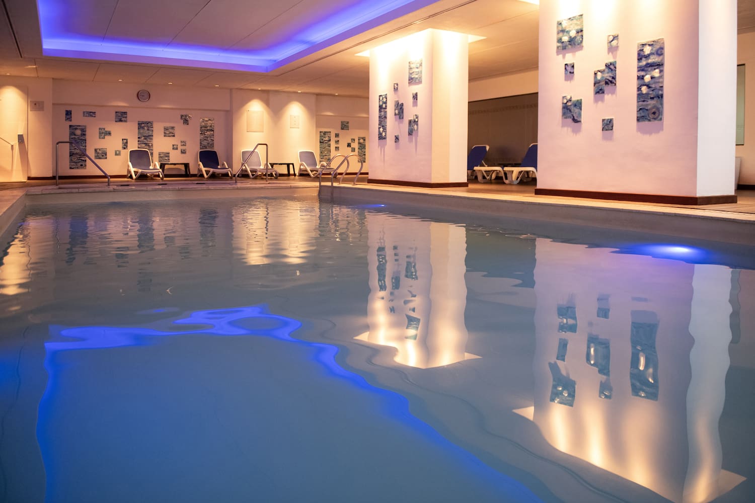 a pool with chairs and a wall