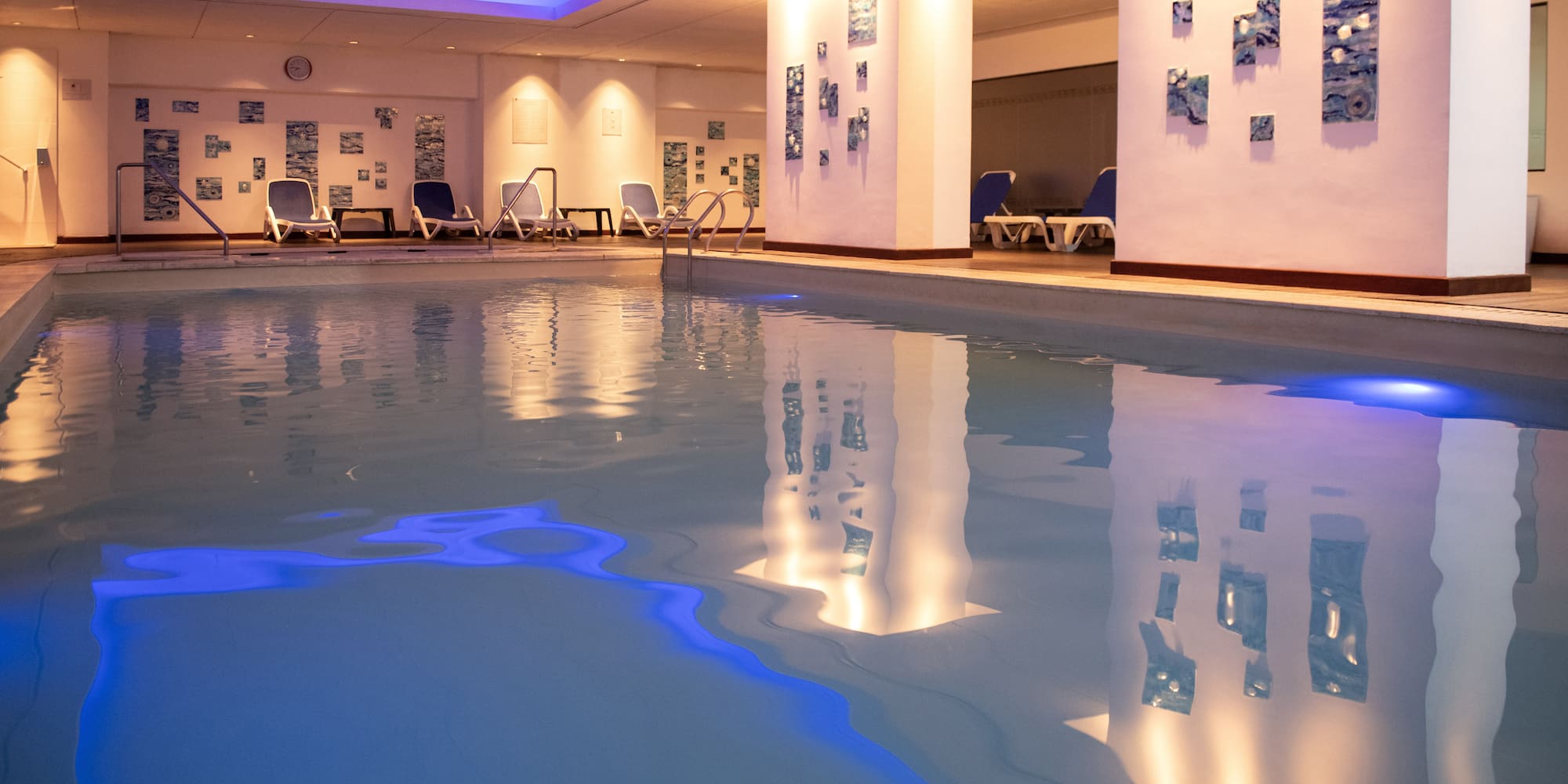 a pool with chairs and a wall