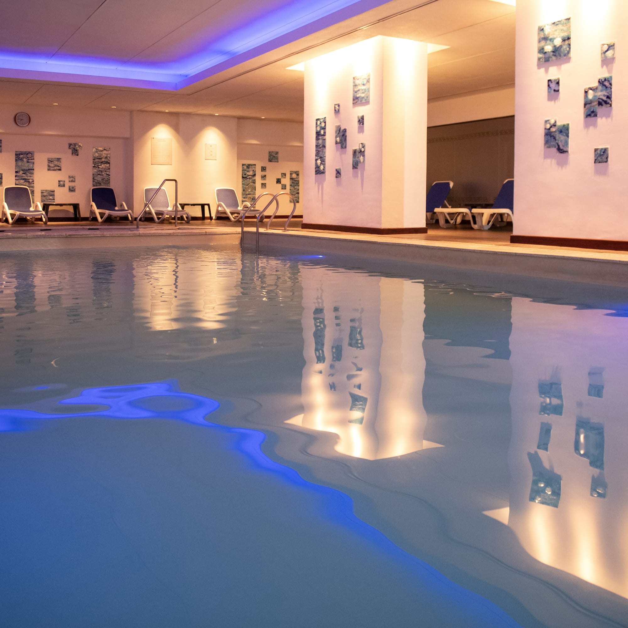 a pool with chairs and a wall