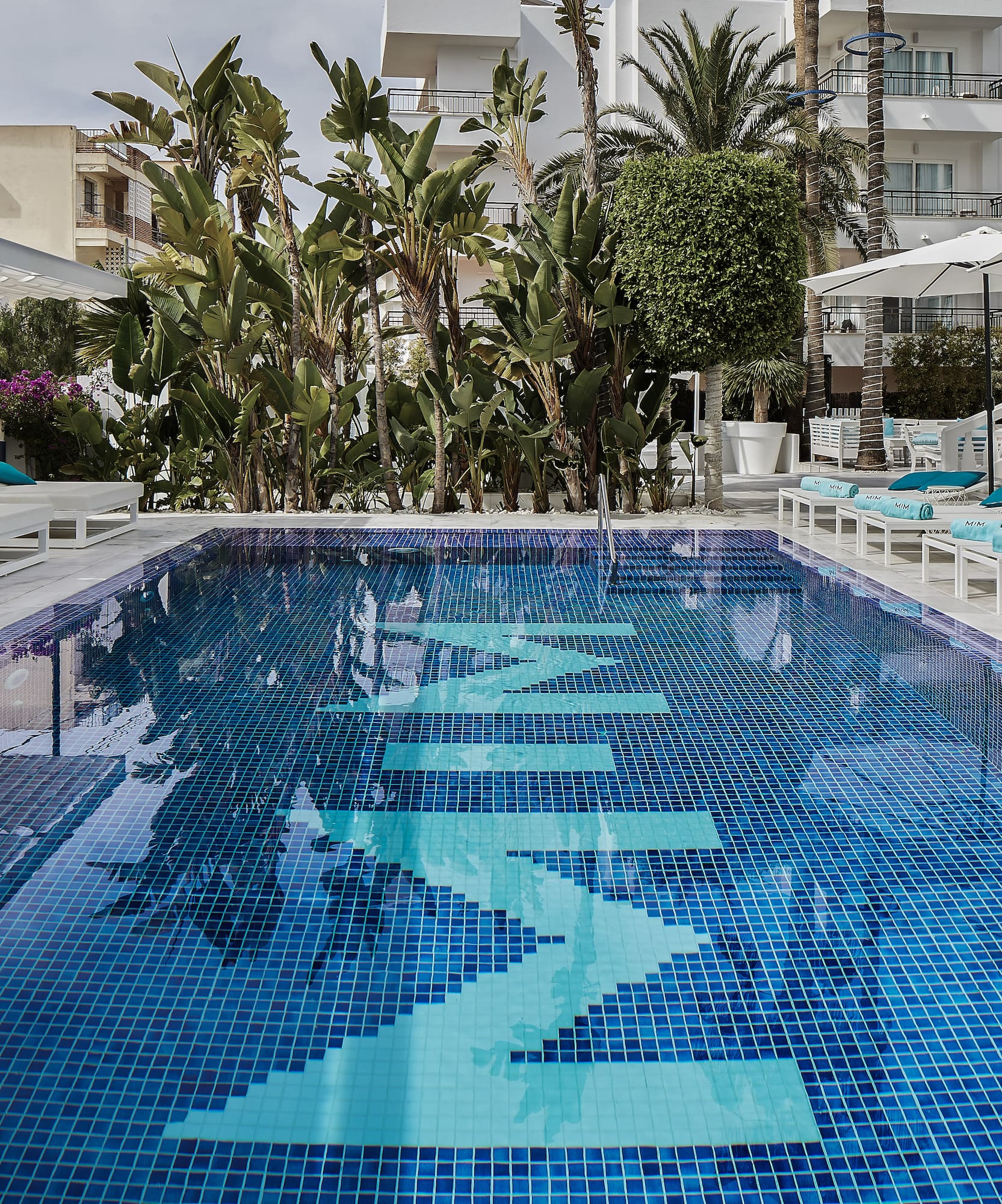 a pool with chairs and umbrellas