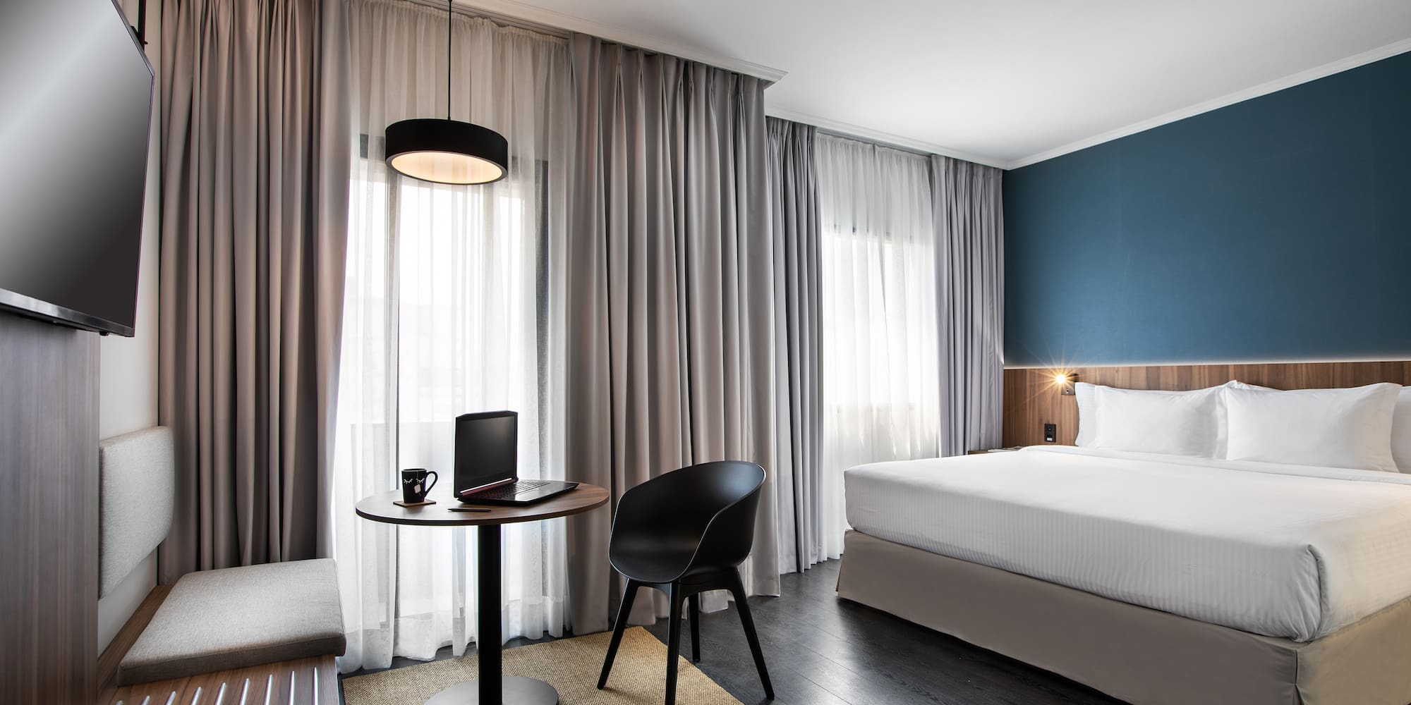 a room with a bed and a laptop