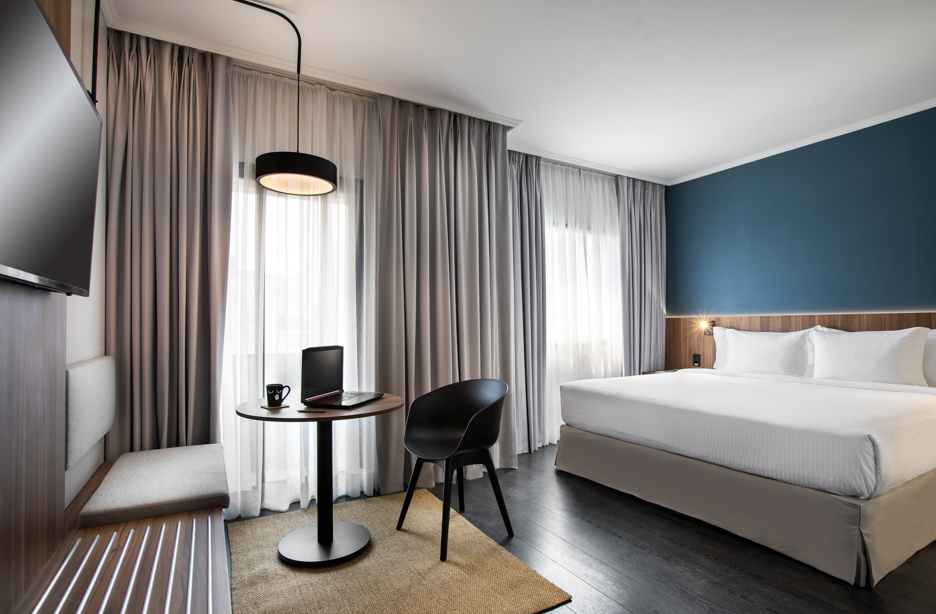 a room with a bed and a laptop