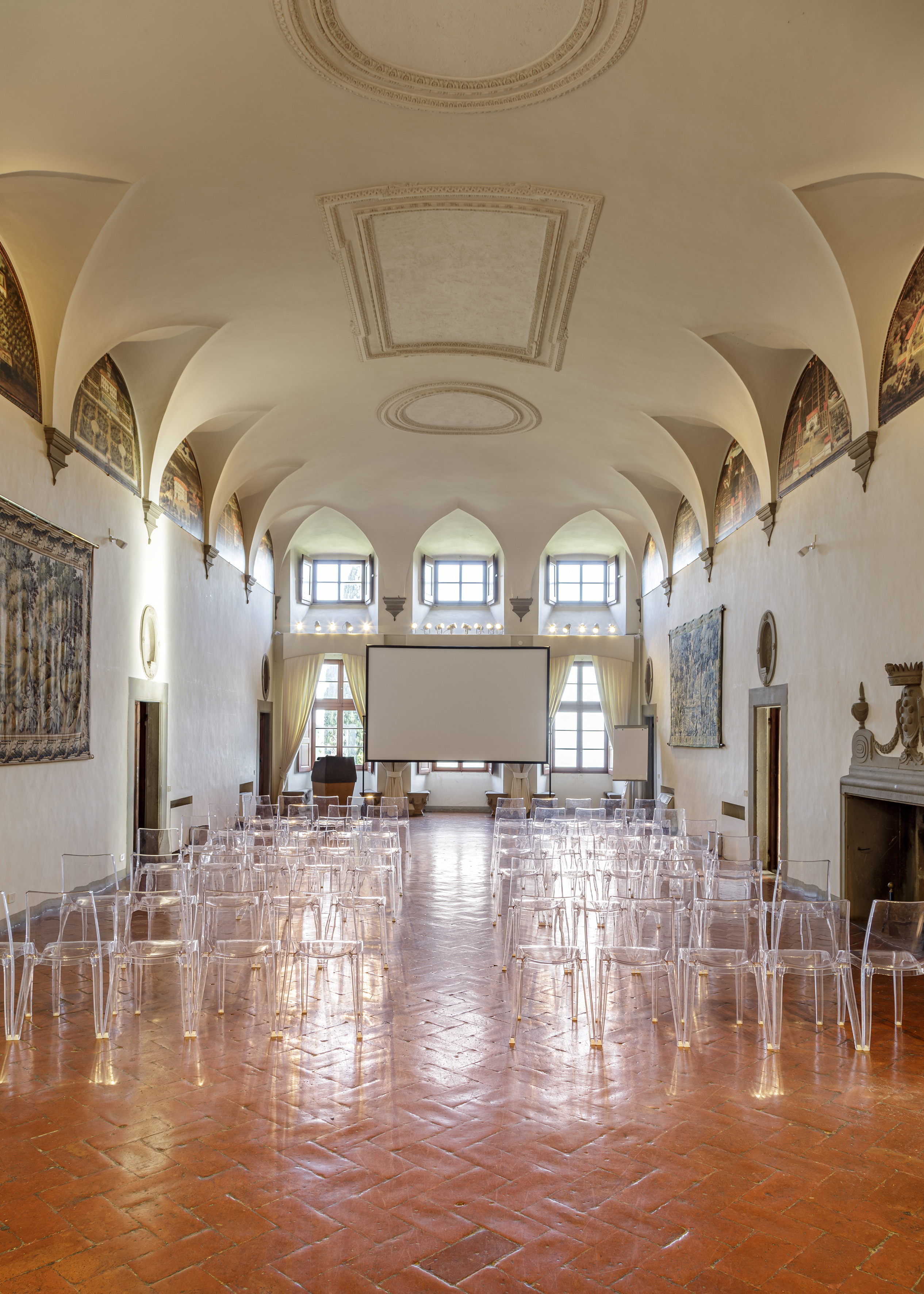a room with many clear chairs and a projector screen