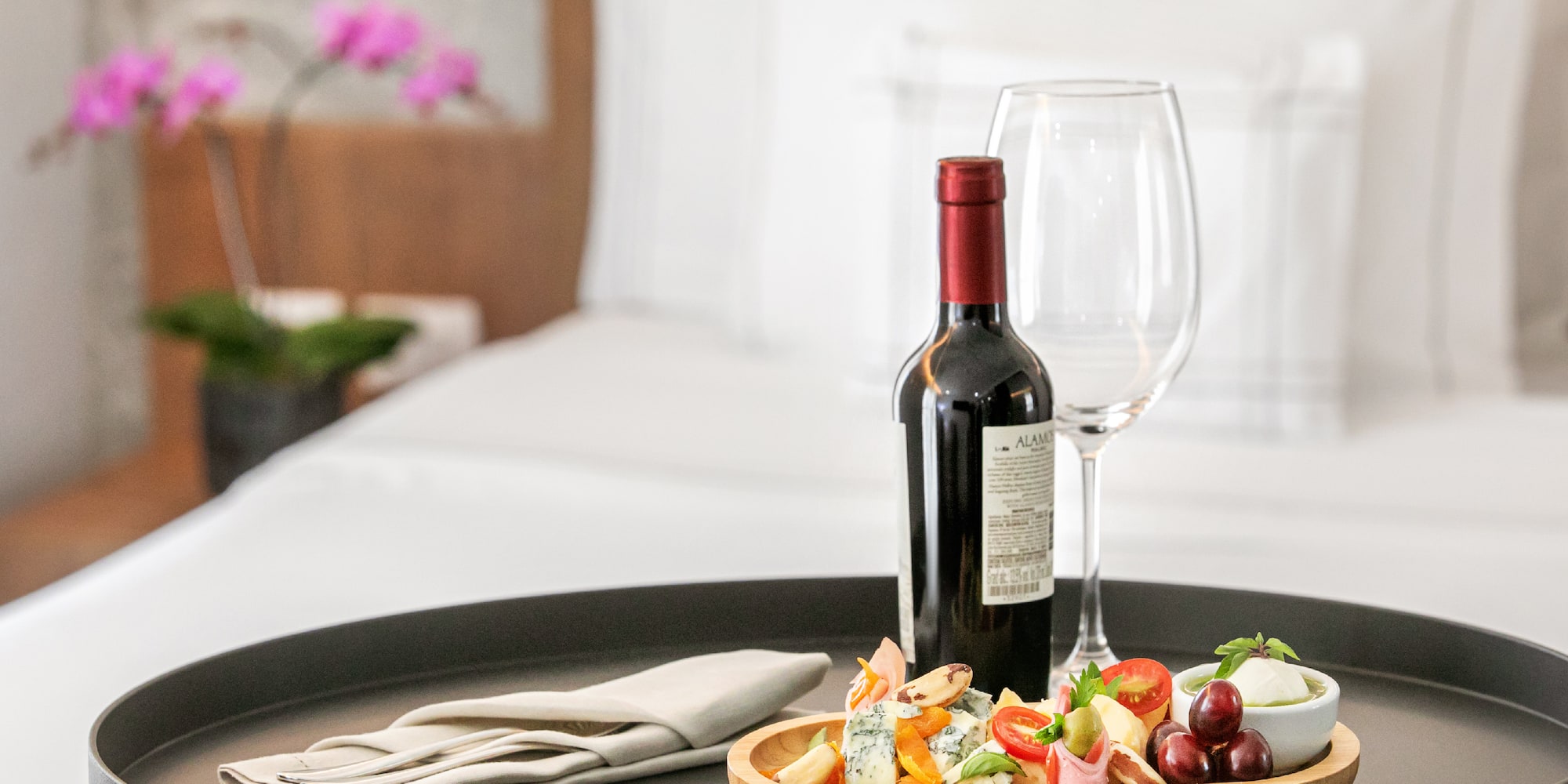 a wine bottle and a plate of food on a tray