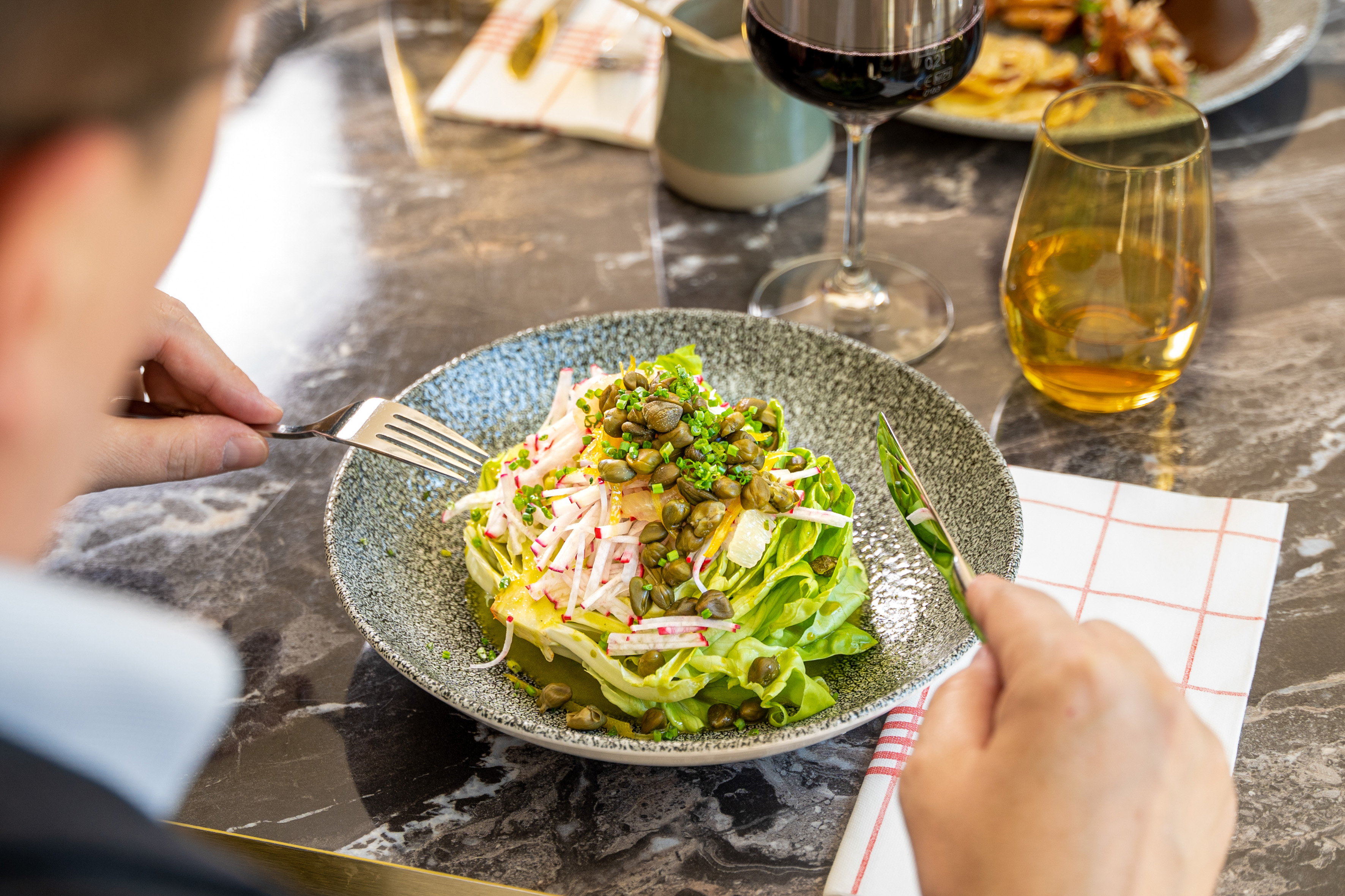 Dining on a fresh salad with capers, radish, and lettuce.