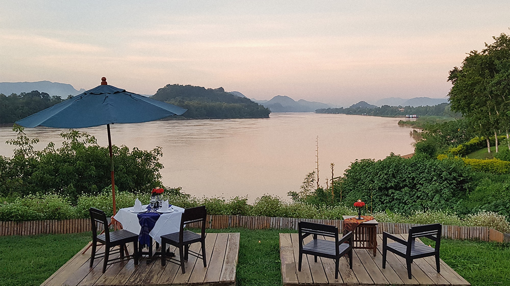 a table and chairs on a deck overlooking a body of water