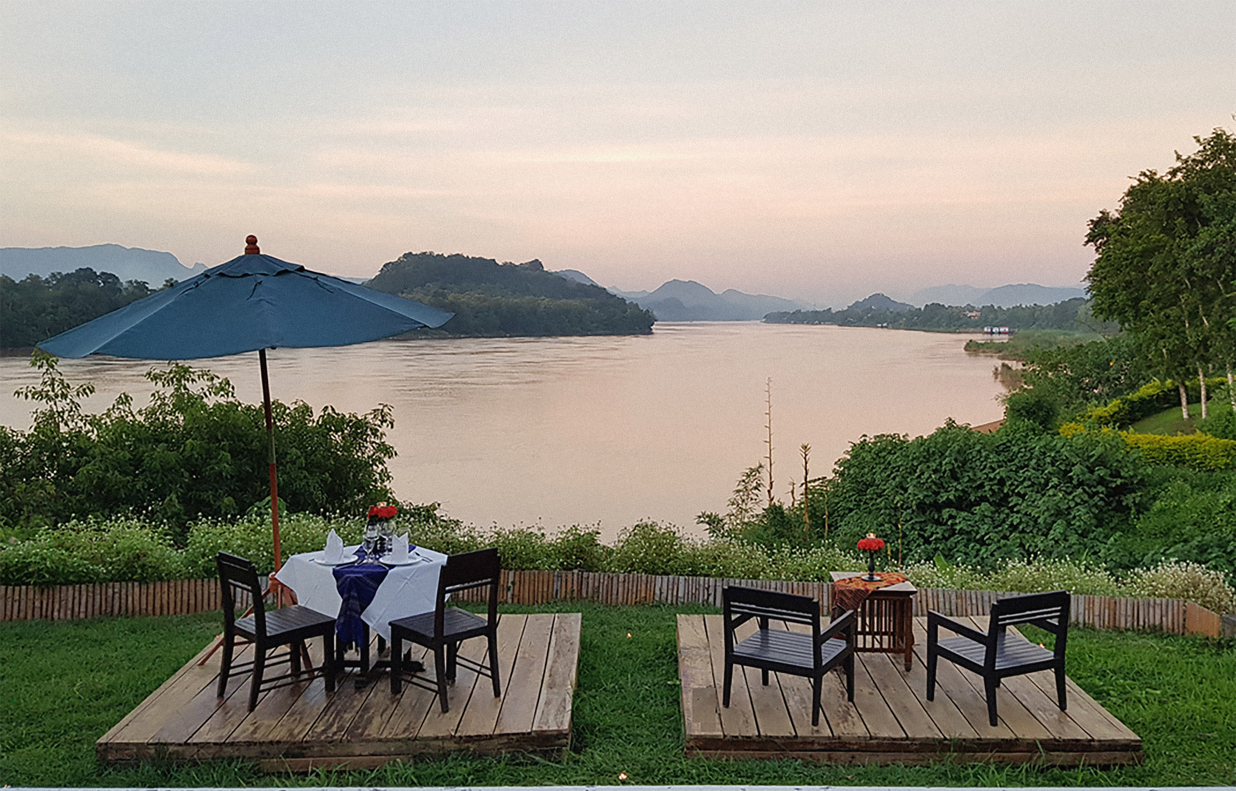 a table and chairs on a deck overlooking a body of water