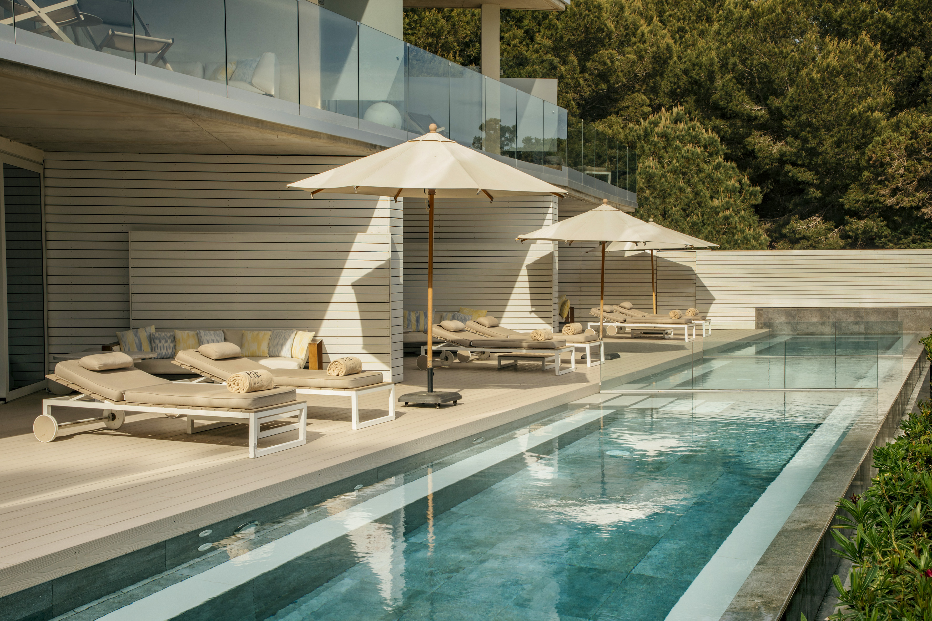 a pool with lounge chairs and umbrellas