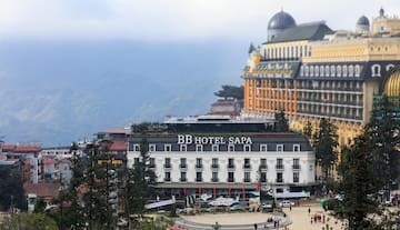 a building with a dome roof and a large building with trees and mountains in the background