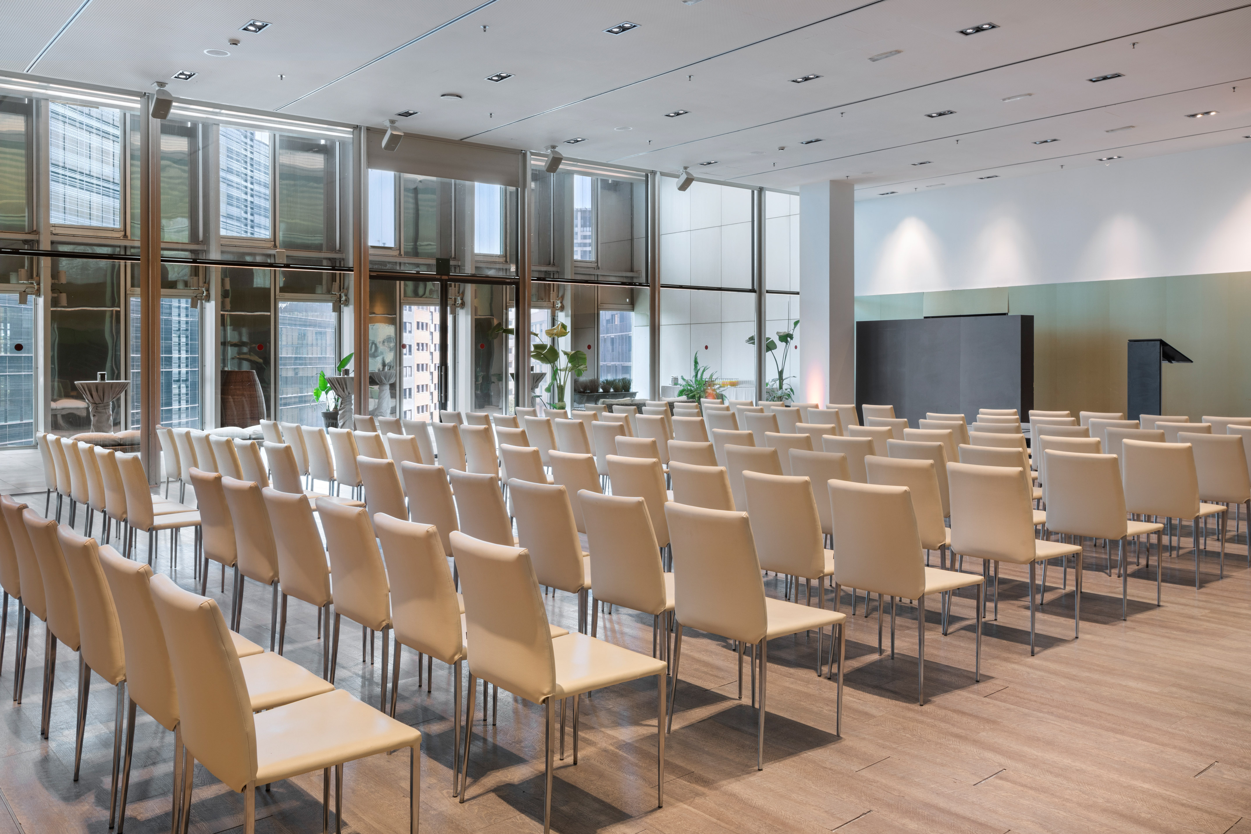 Modern conference room with empty chairs, screen, podium, city view. - Evolution - Meliá Barcelona Sky, Barcelona