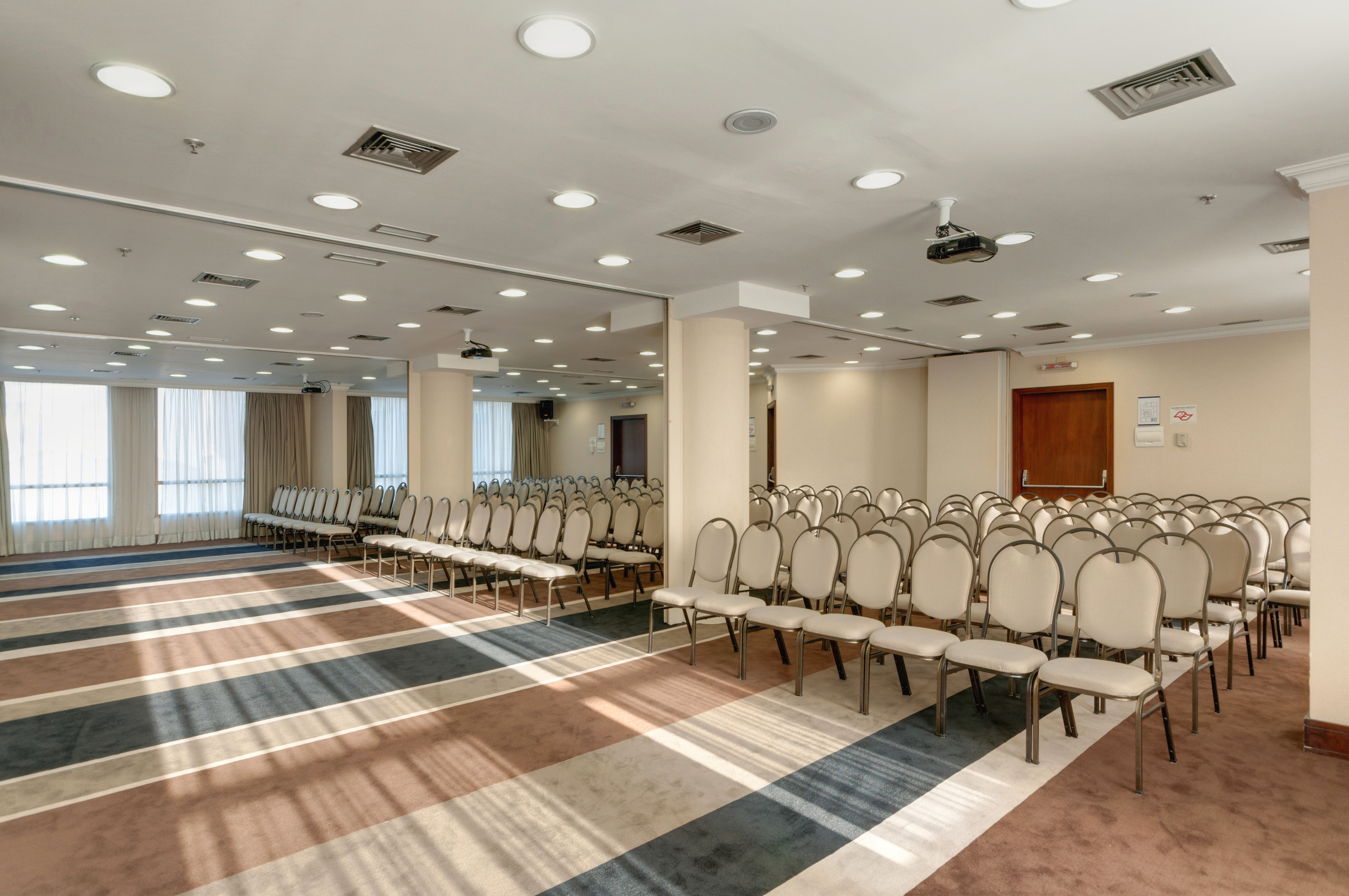 Conference room with chairs, patterned carpet, and ceiling projector.