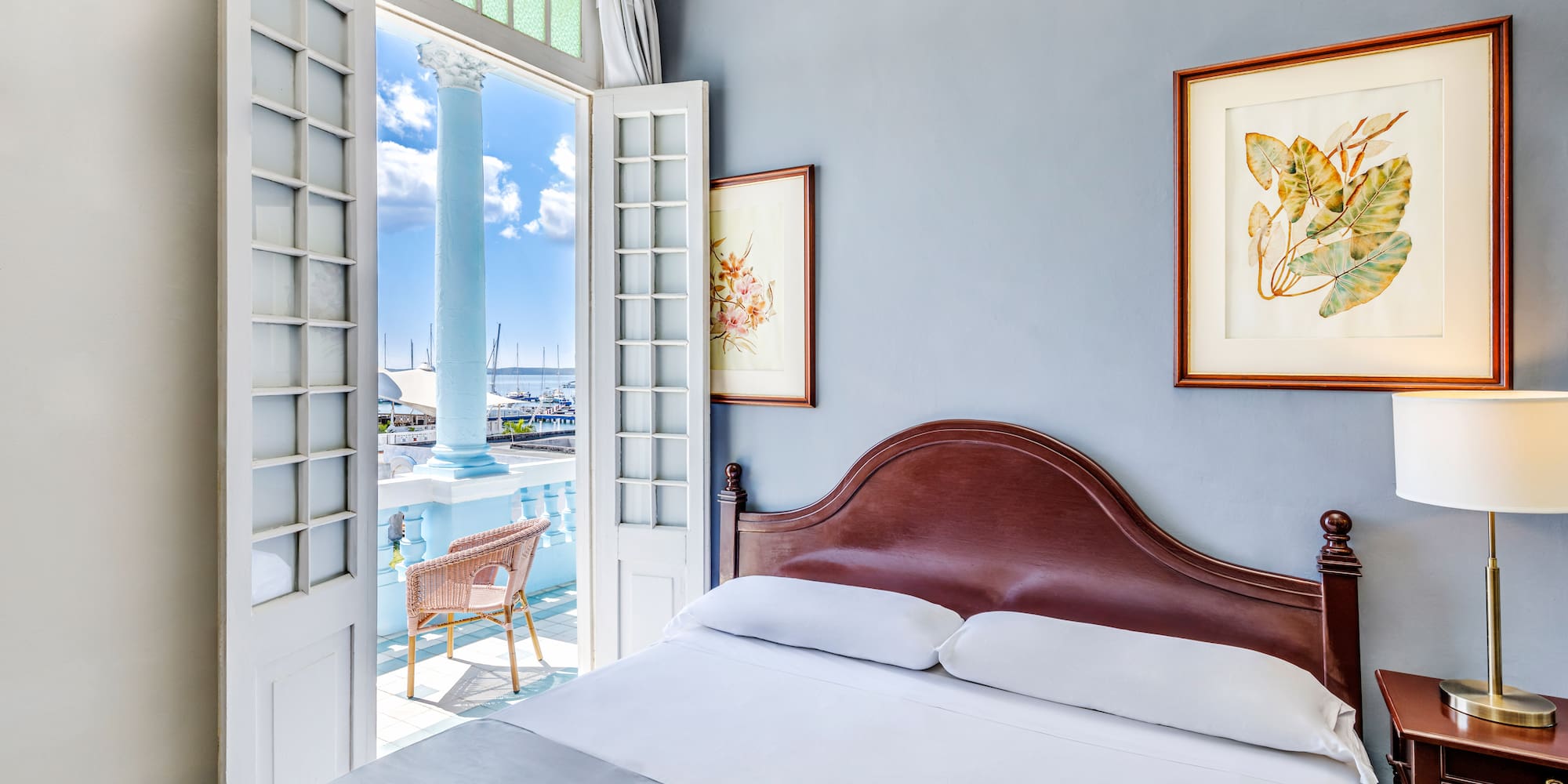 a bed with a headboard and a door open to a balcony