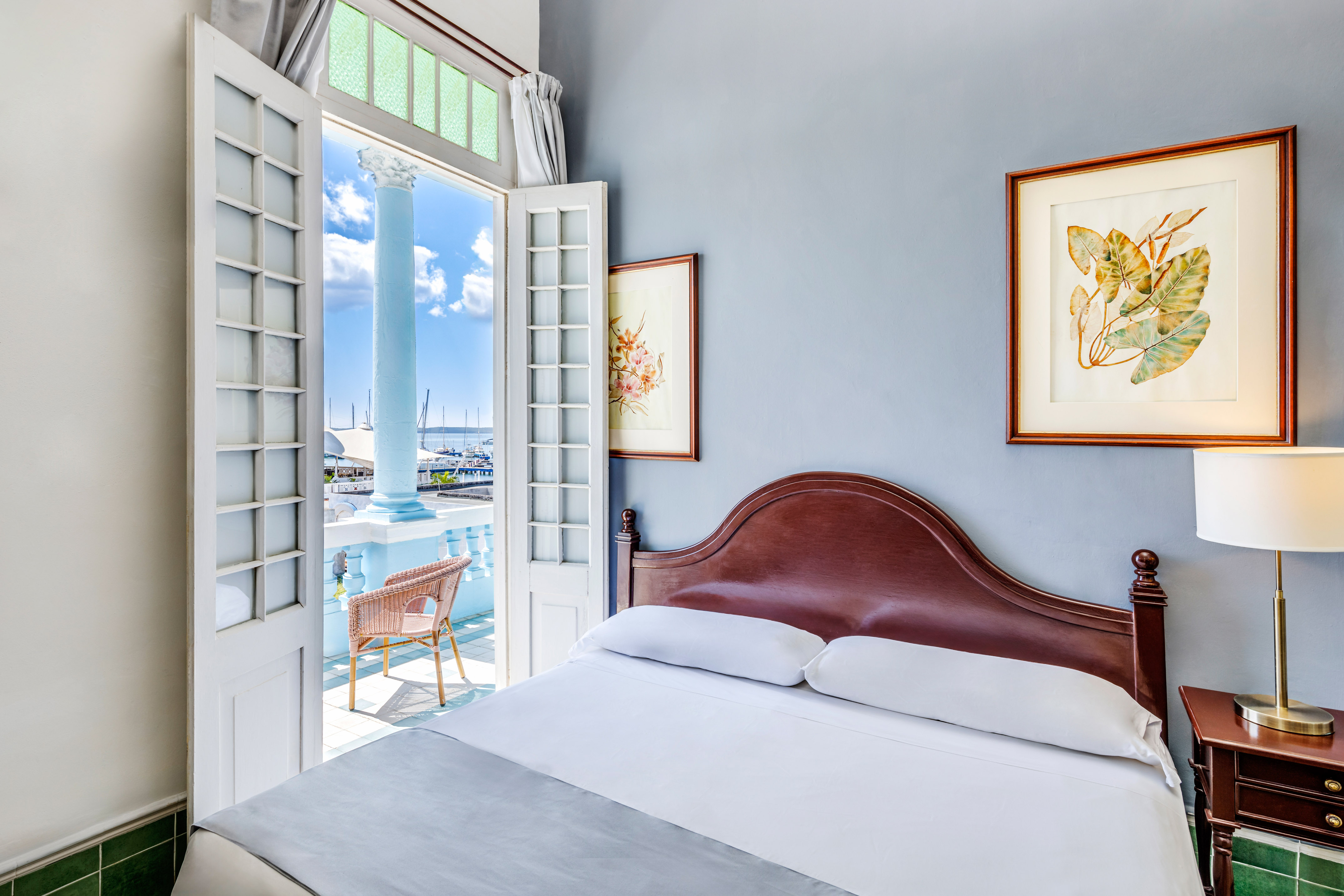 a bed with a headboard and a door open to a balcony