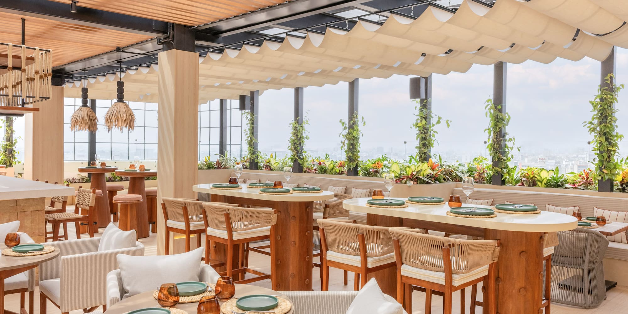 Rooftop restaurant, natural decor, outdoor dining, city view, canopy ceiling.