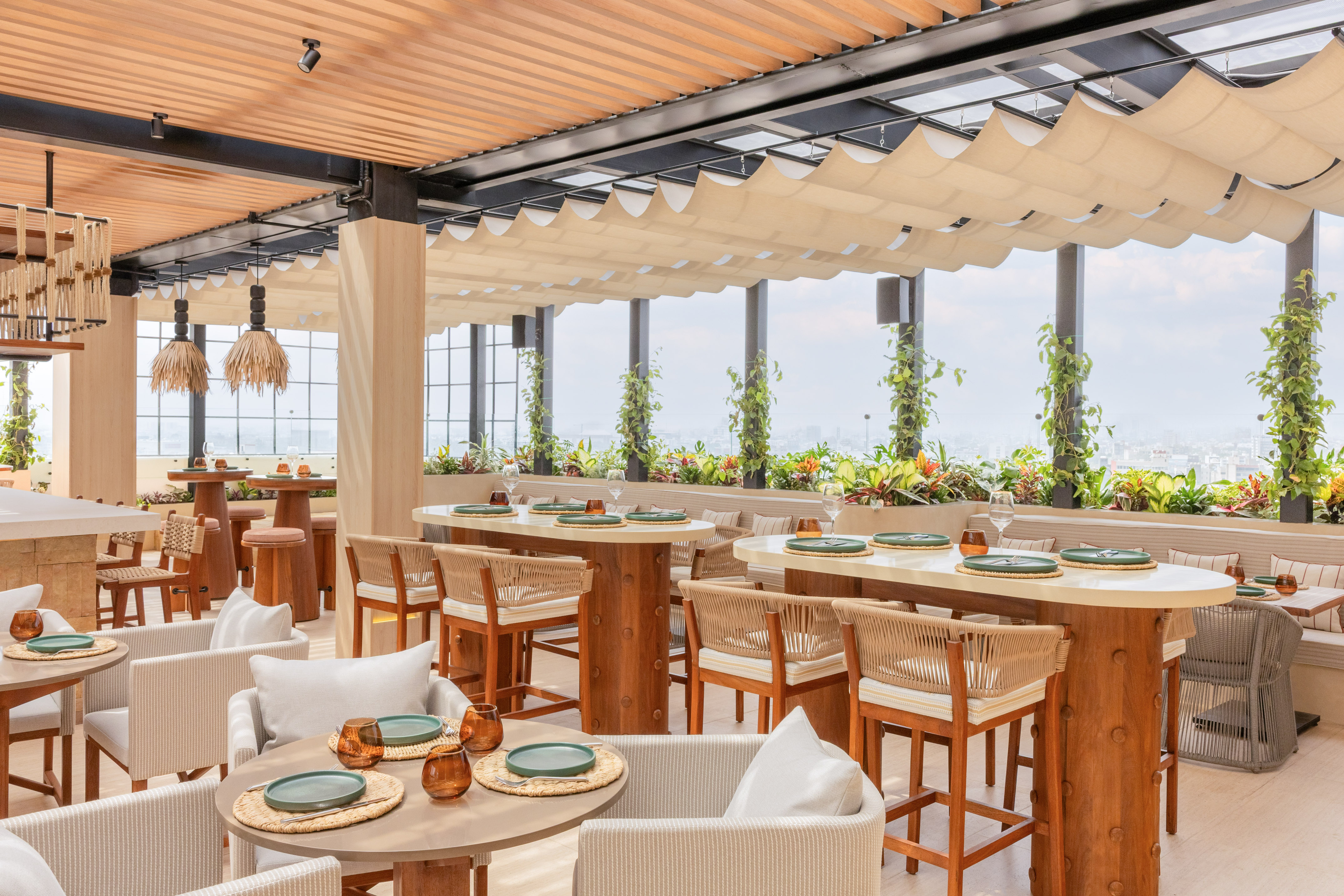 Rooftop restaurant, natural decor, outdoor dining, city view, canopy ceiling.