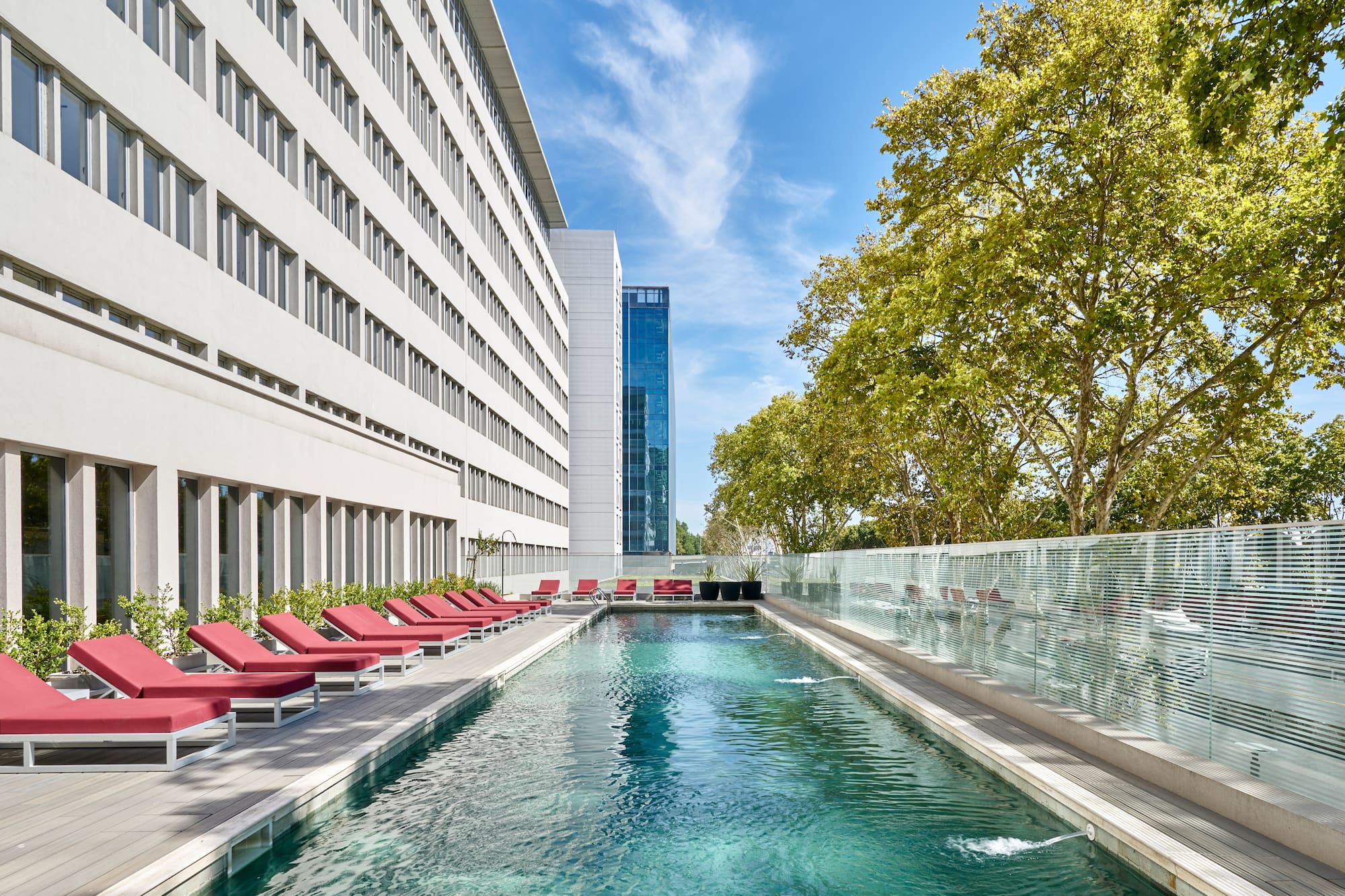 a pool with chairs and a building in the background