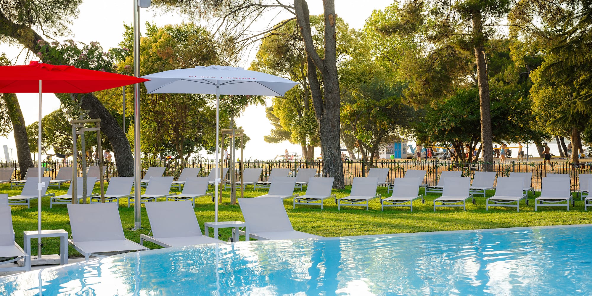 a pool with chairs and umbrellas in the middle