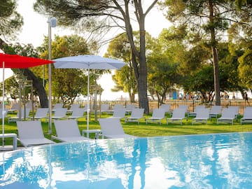 a pool with chairs and umbrellas in the middle