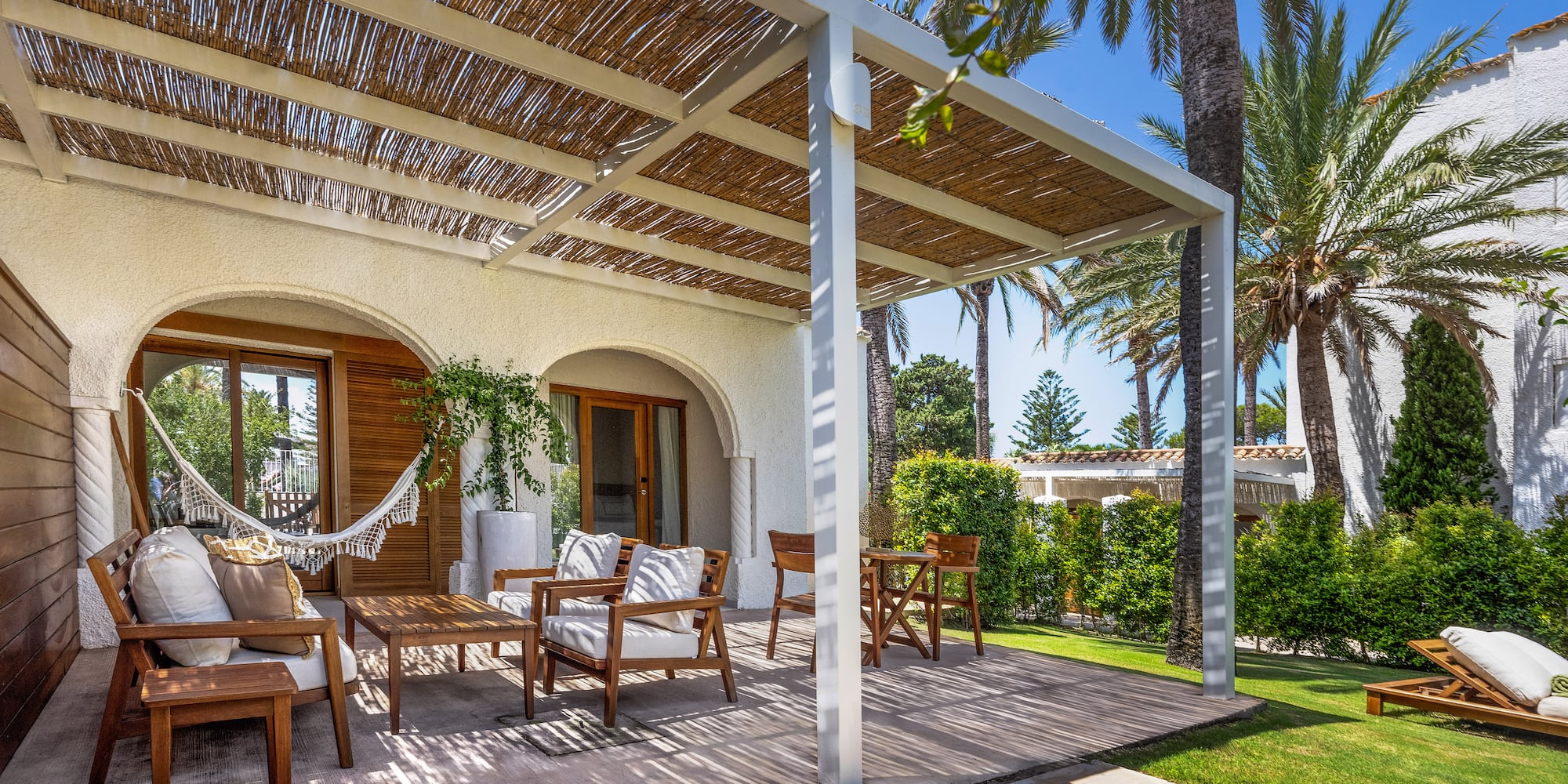 a patio with chairs and a hammock