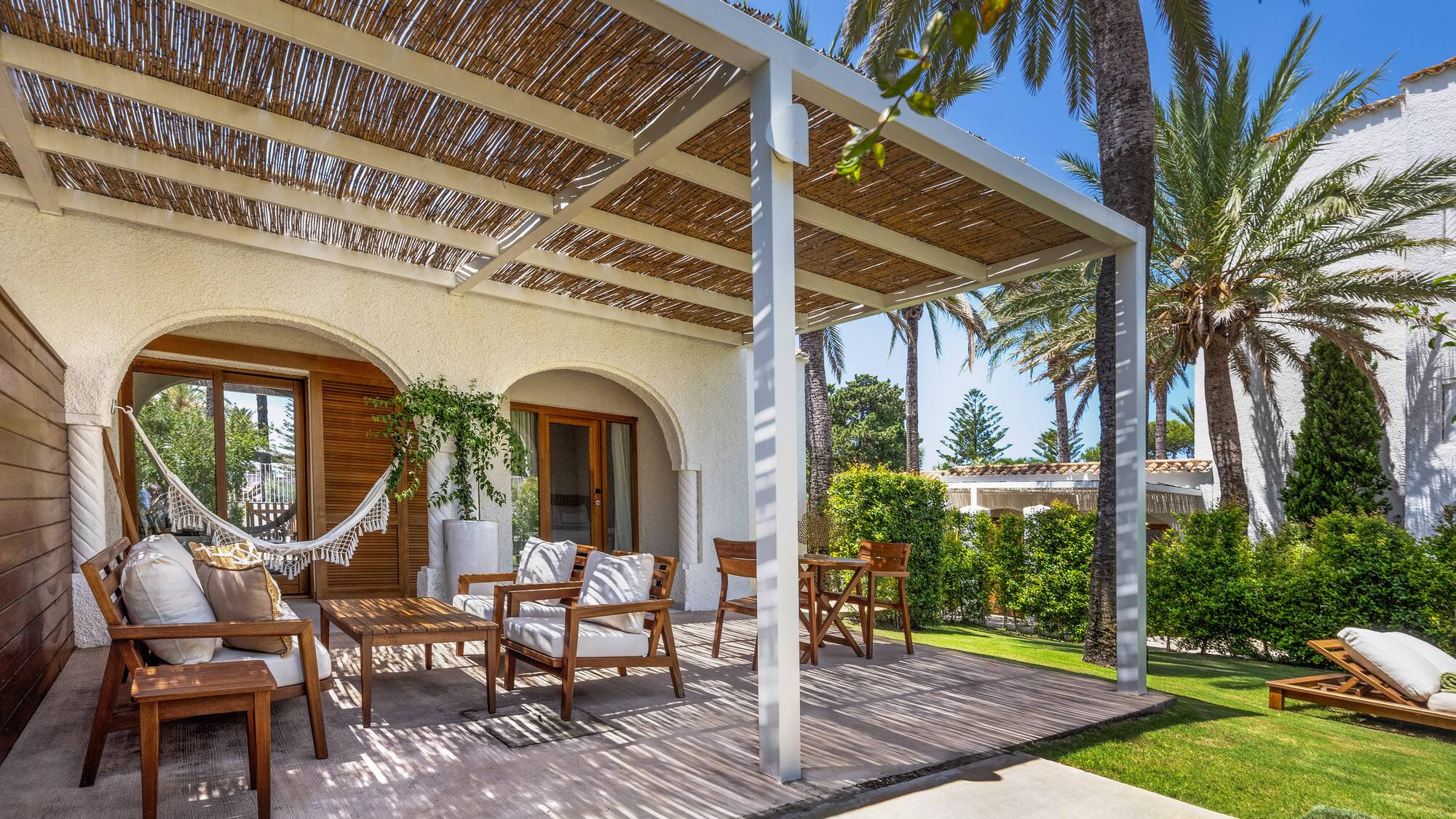 a patio with chairs and a hammock