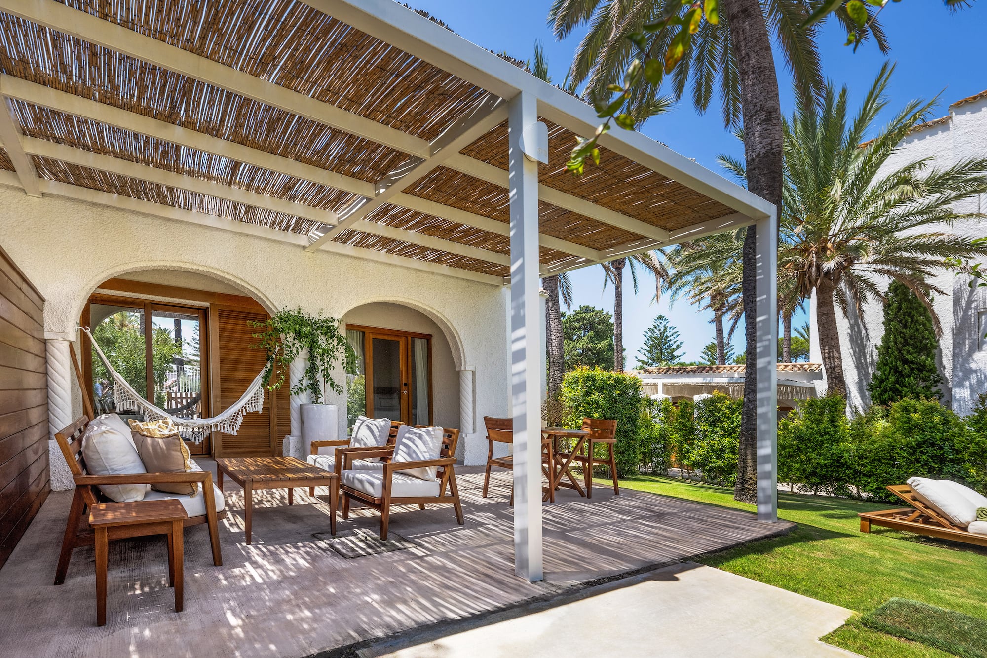 a patio with chairs and a hammock
