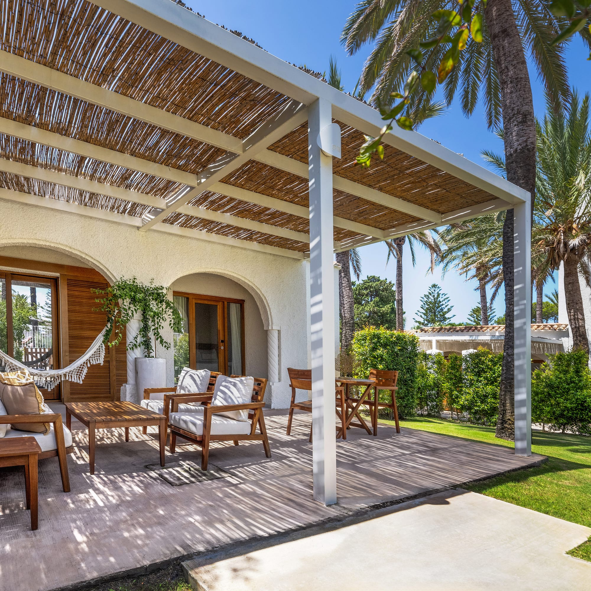 a patio with chairs and a hammock