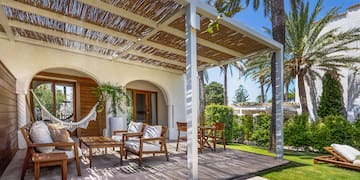 a patio with chairs and a hammock