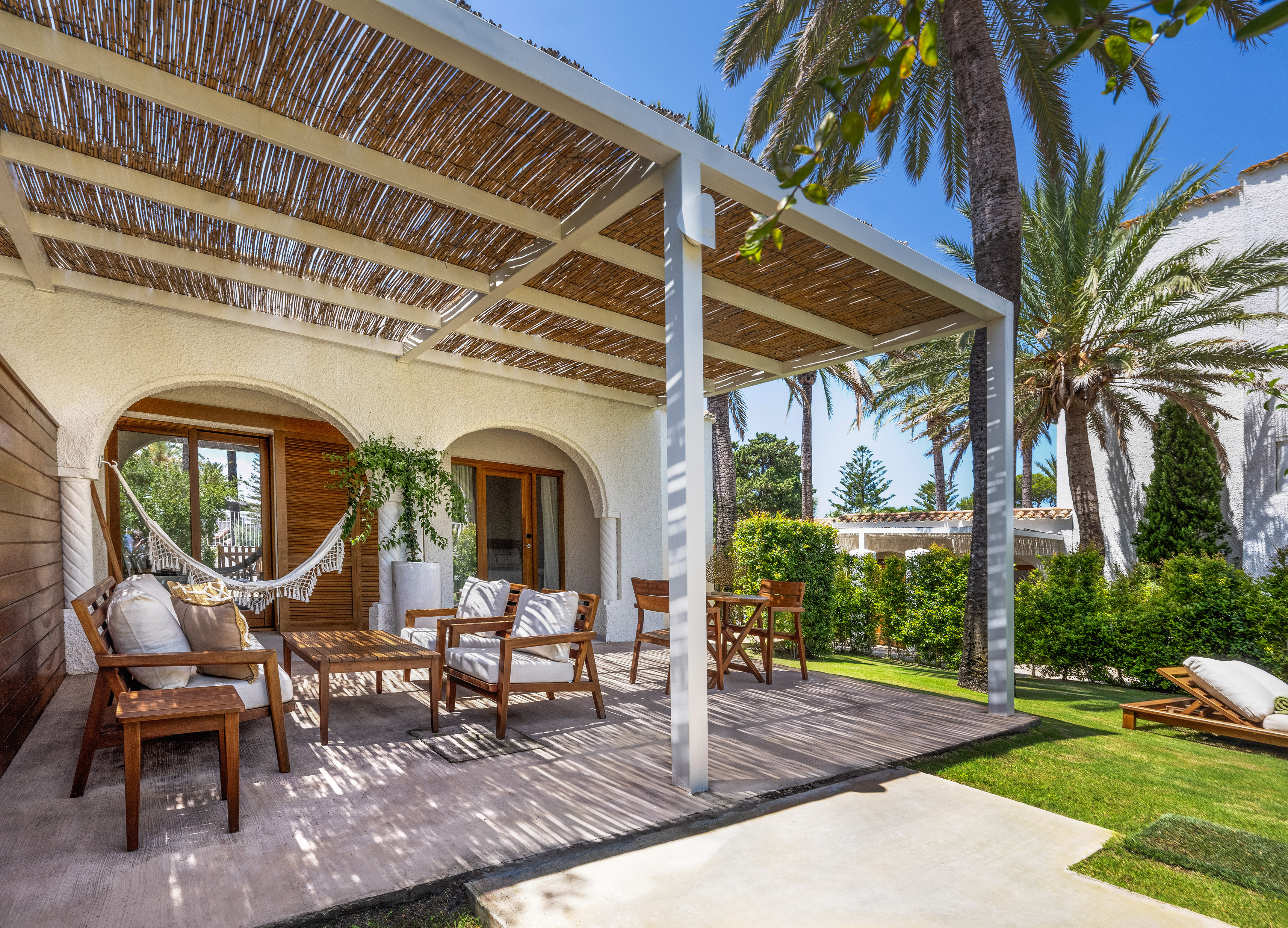 a patio with chairs and a hammock