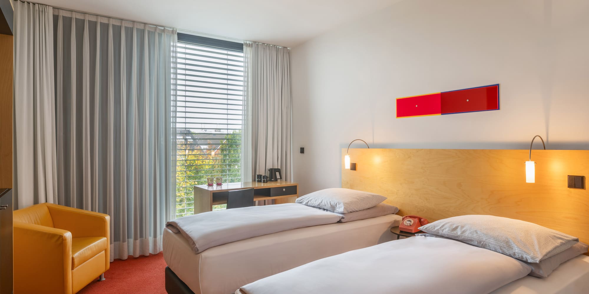 a room with two beds and a yellow chair